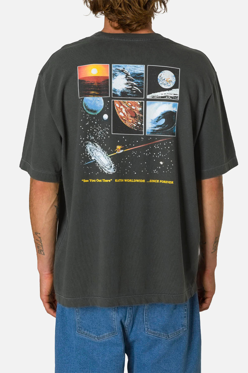 Person wearing a black t-shirt with space-themed graphics on the back