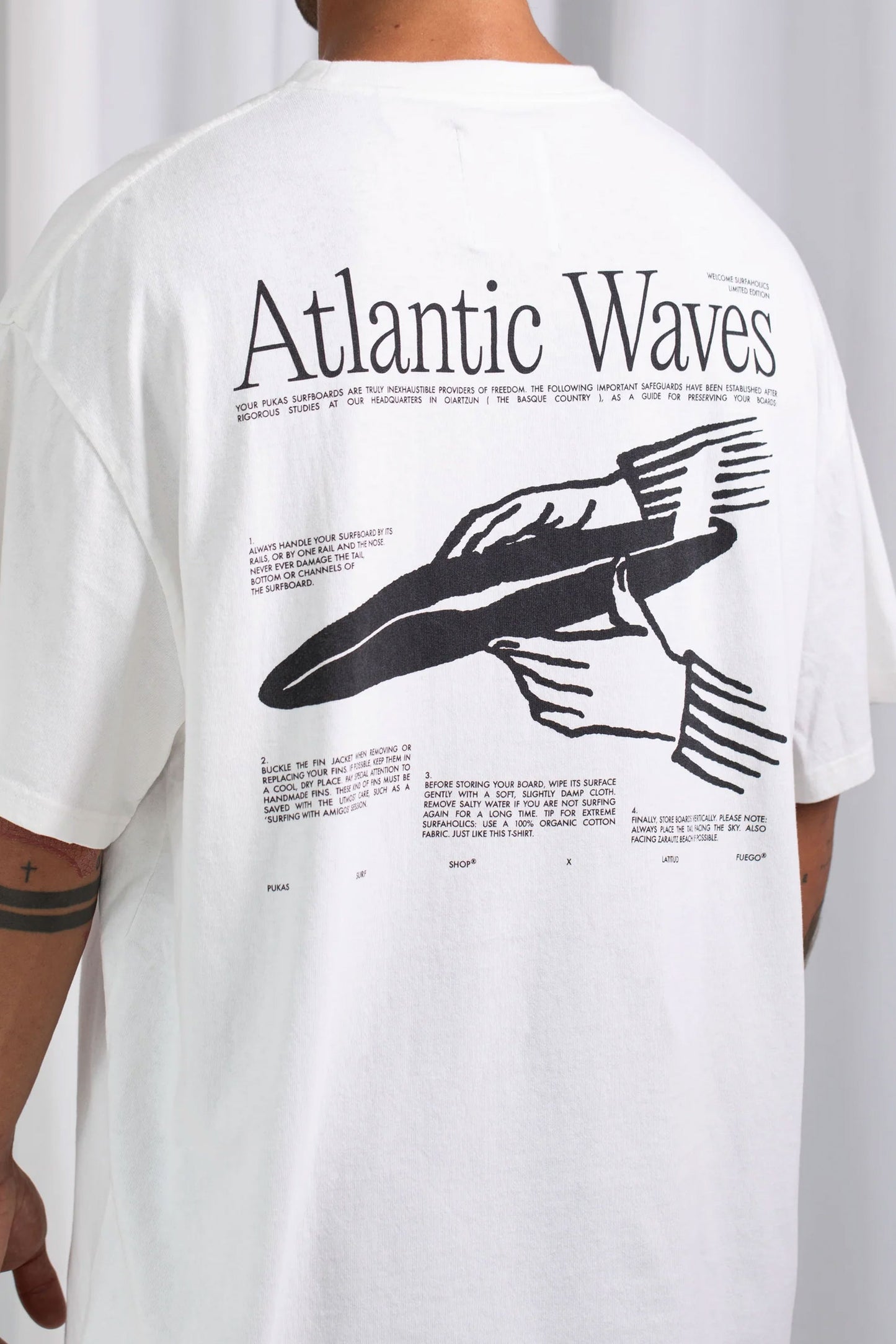 Latitud fuego x Pukas Surf Shop White t-shirt with black graphic design and text on the back 