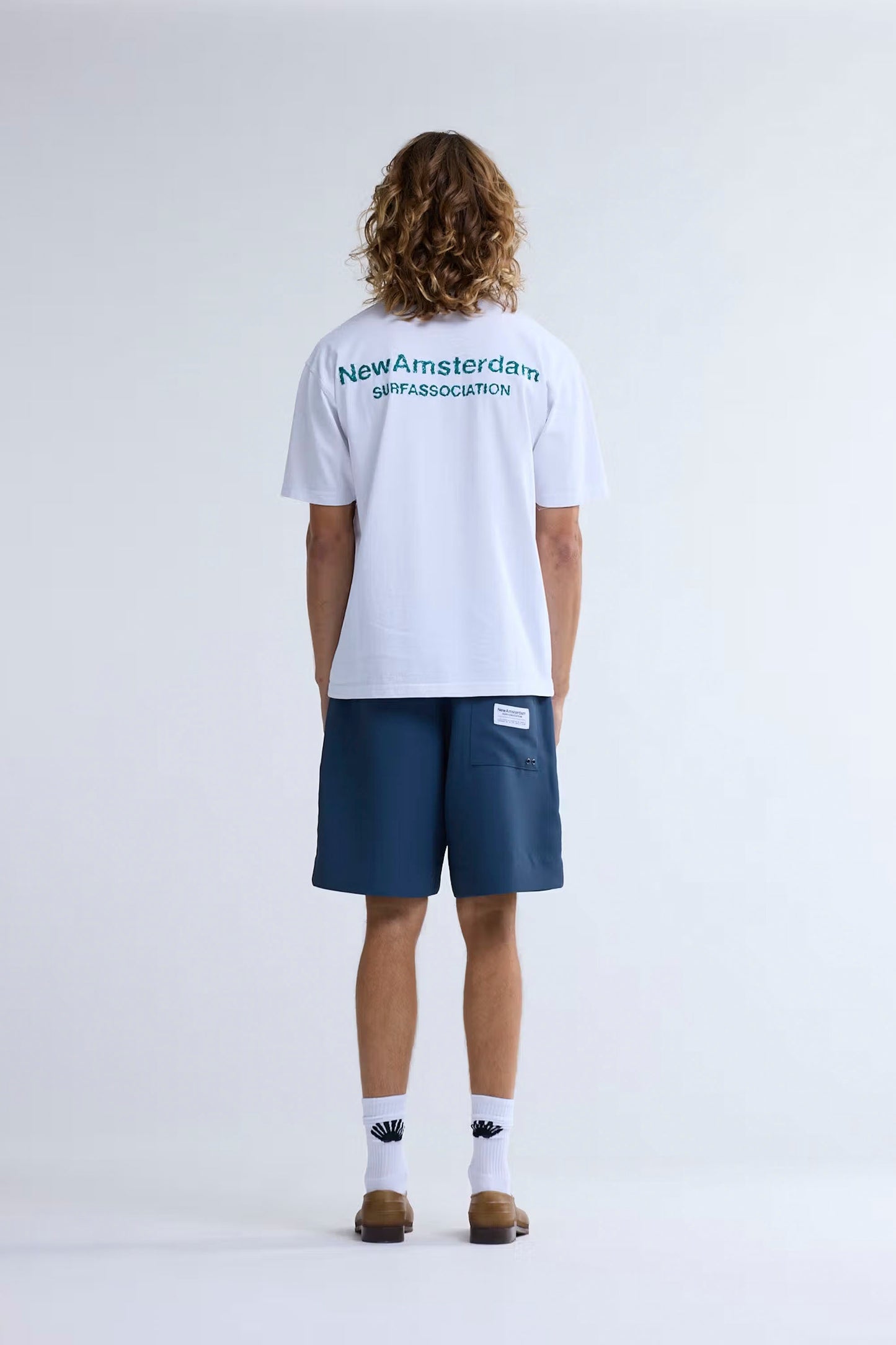 New Amsterdam Surf Association Logo Tee white sea green back view showing high-low embroidered branding and ribbed collar