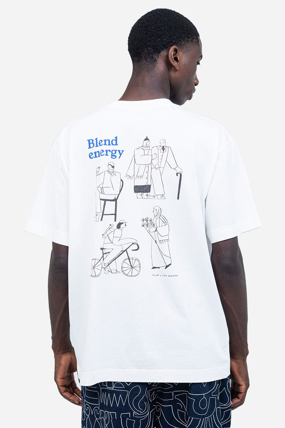 Person wearing a white t-shirt with graphic designs and text on a white background