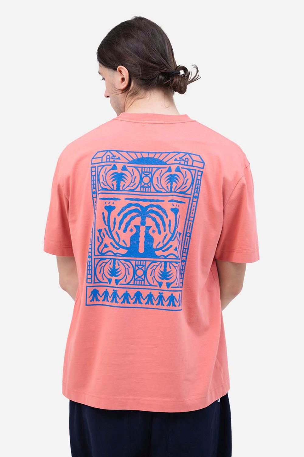 Person wearing a pink t-shirt with a blue graphic design on a white background