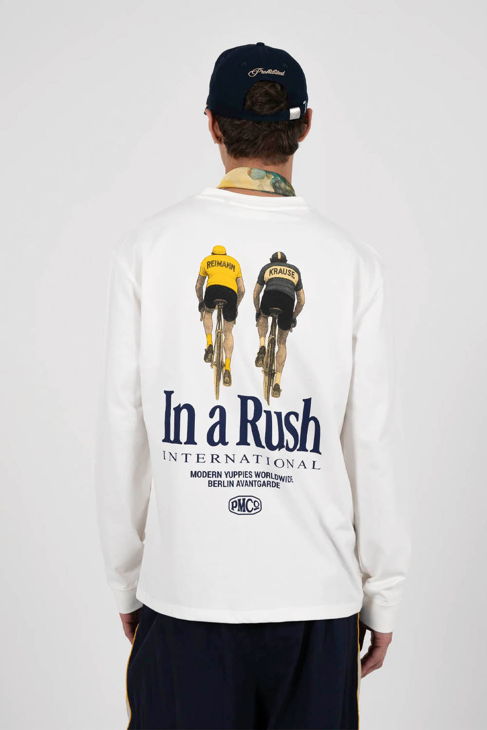 Person wearing a white long-sleeve shirt with 'In a Rush' graphic and text on the back.