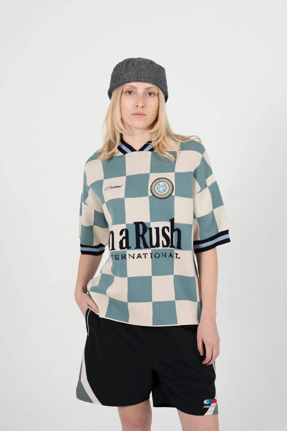 Person wearing a checkered shirt with visible branding on a white background