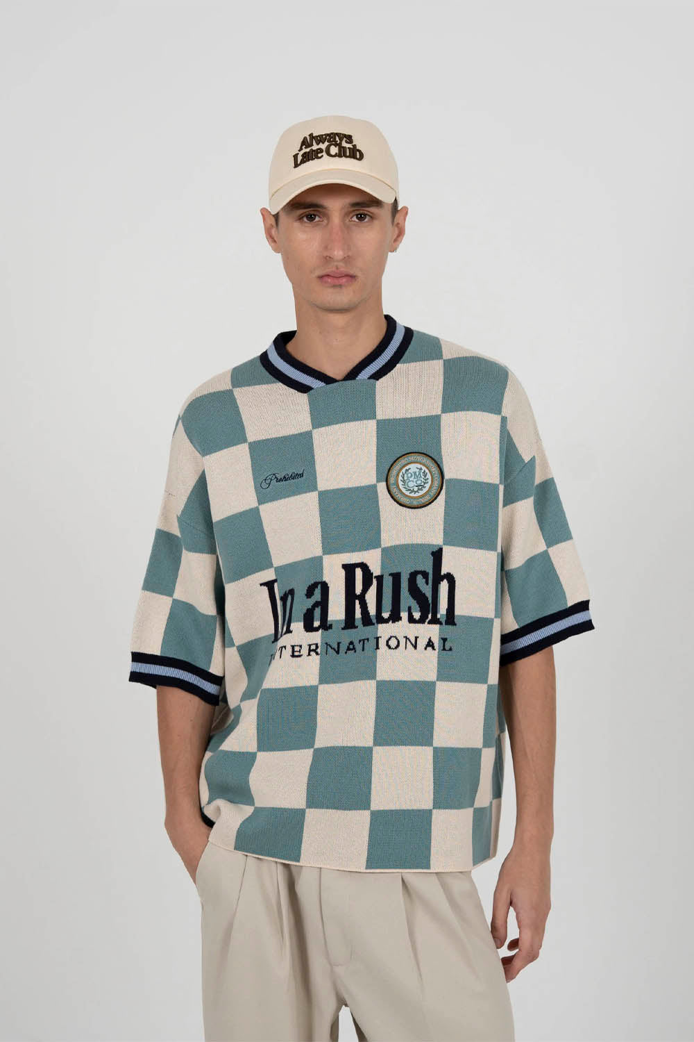 Person wearing a checkered shirt with visible branding on a white background