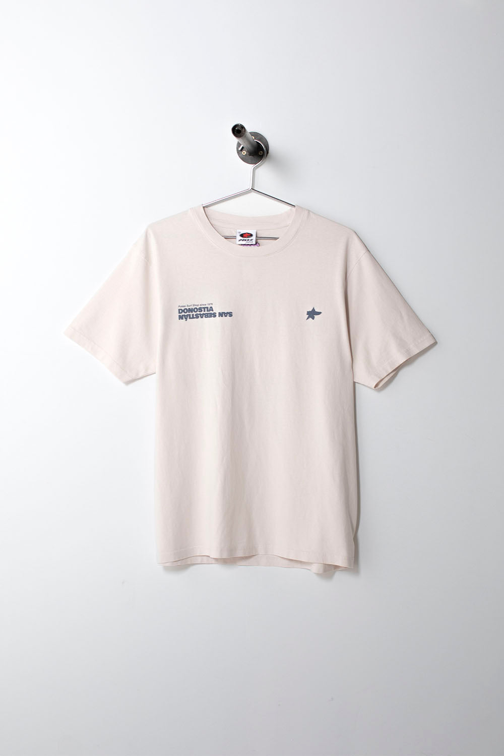Beige t-shirt with small logo on a hanger against a white background