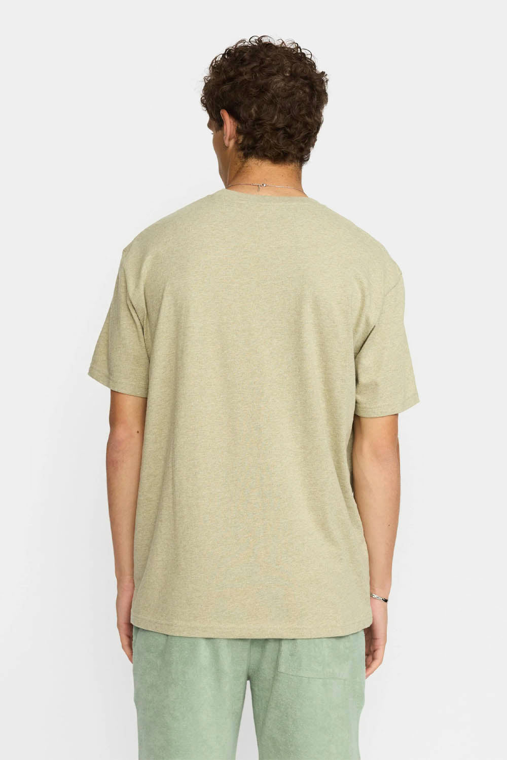 Person wearing a light green t-shirt and pants on a white background