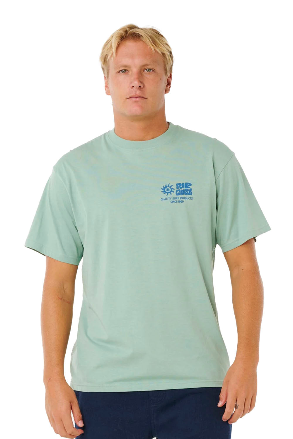 Man wearing a light green t-shirt with a logo on a white background