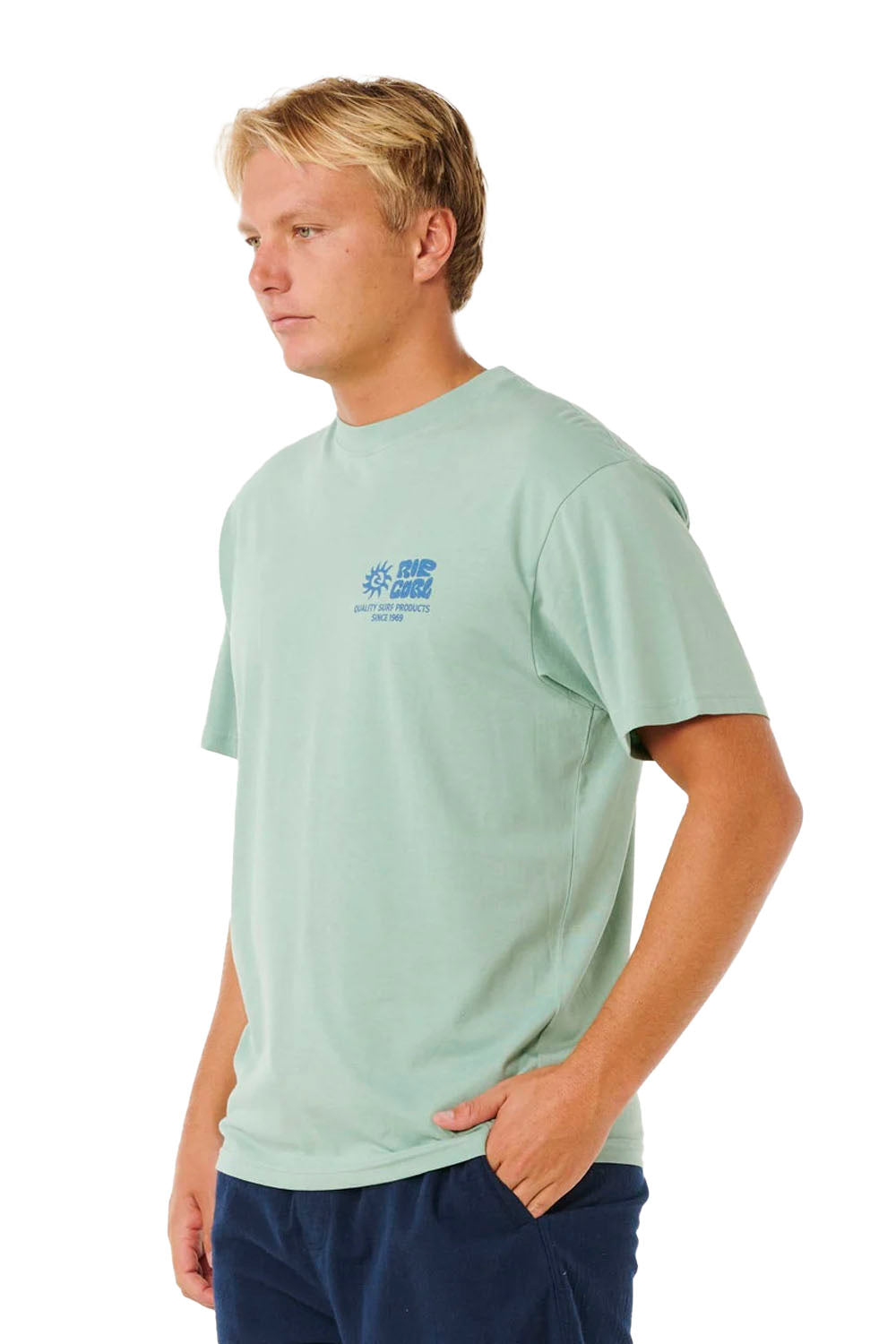 Man wearing a light green t-shirt with a logo on a white background