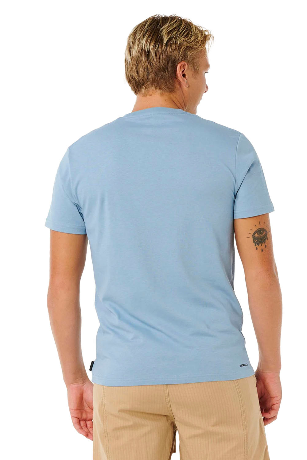Man wearing a light blue t-shirt and beige pants on a white background