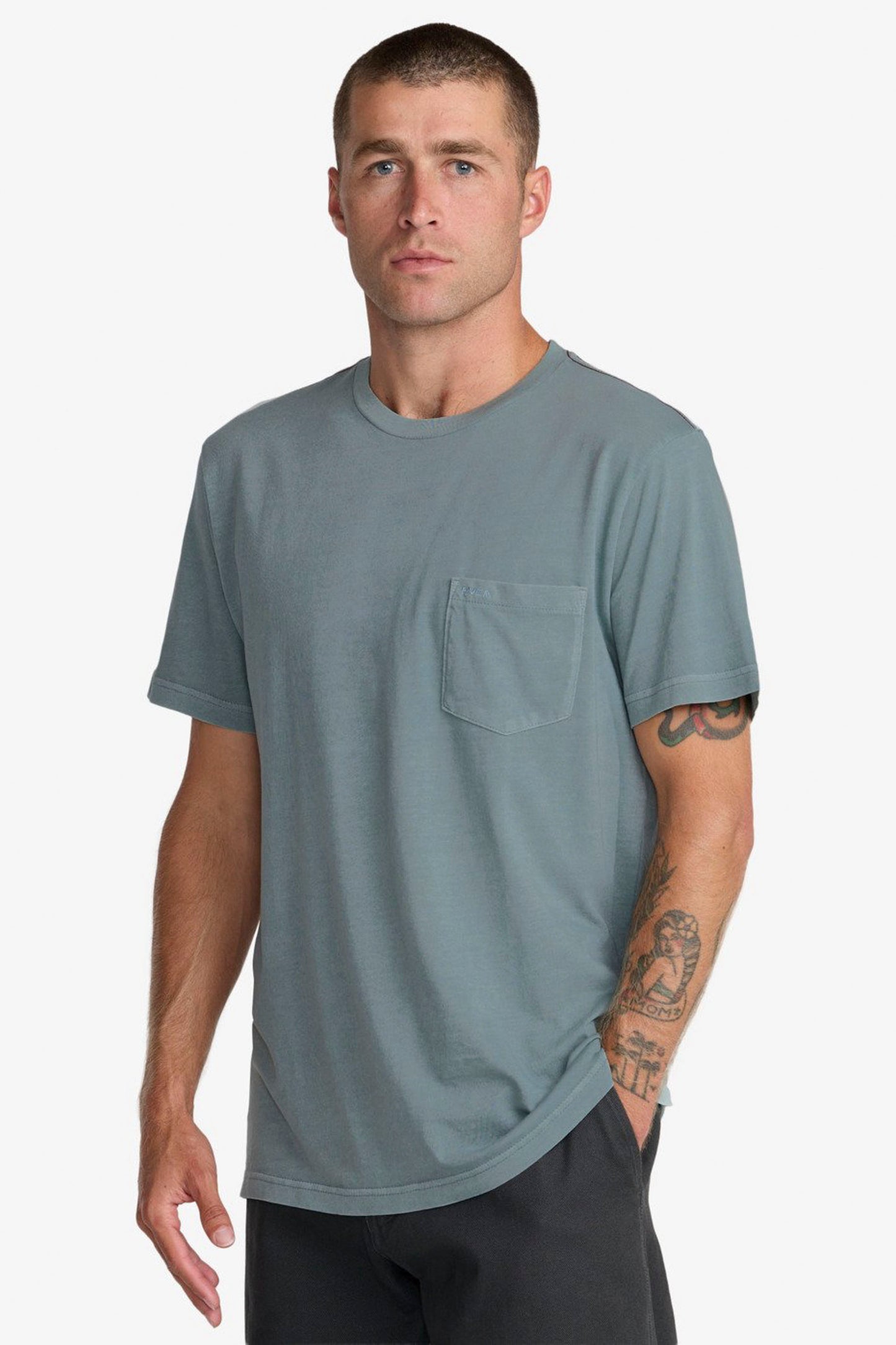 Man wearing a Blue Rvca t-shirt with a pocket on a white background
