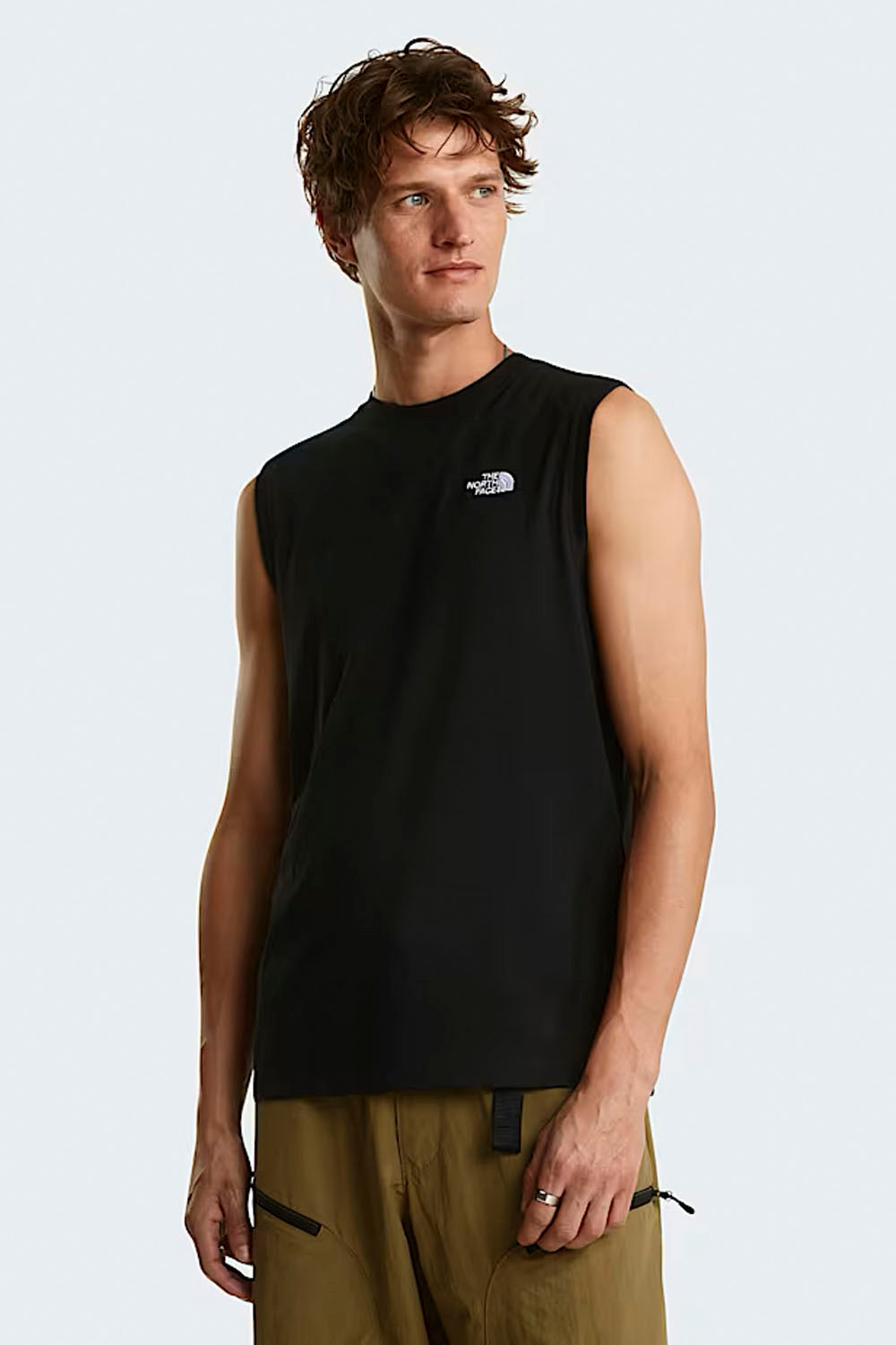 Man wearing a black sleeveless shirt with a logo on a white background