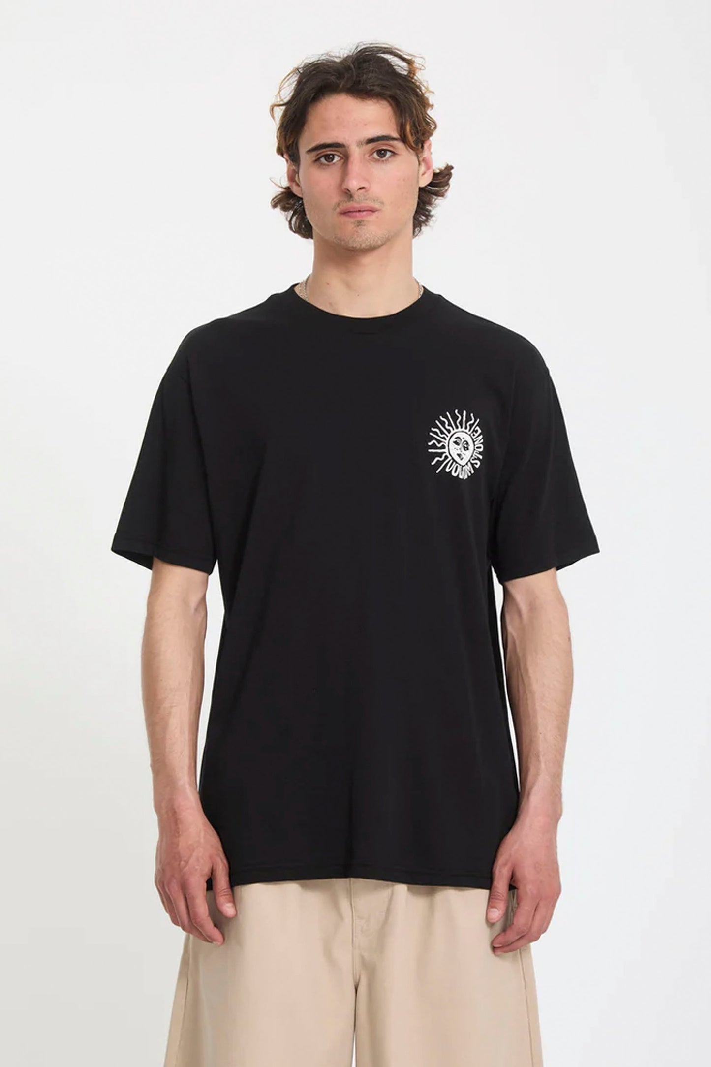 Person wearing a black Volcom Mazatlan t-shirt with a white graphic design on a white background