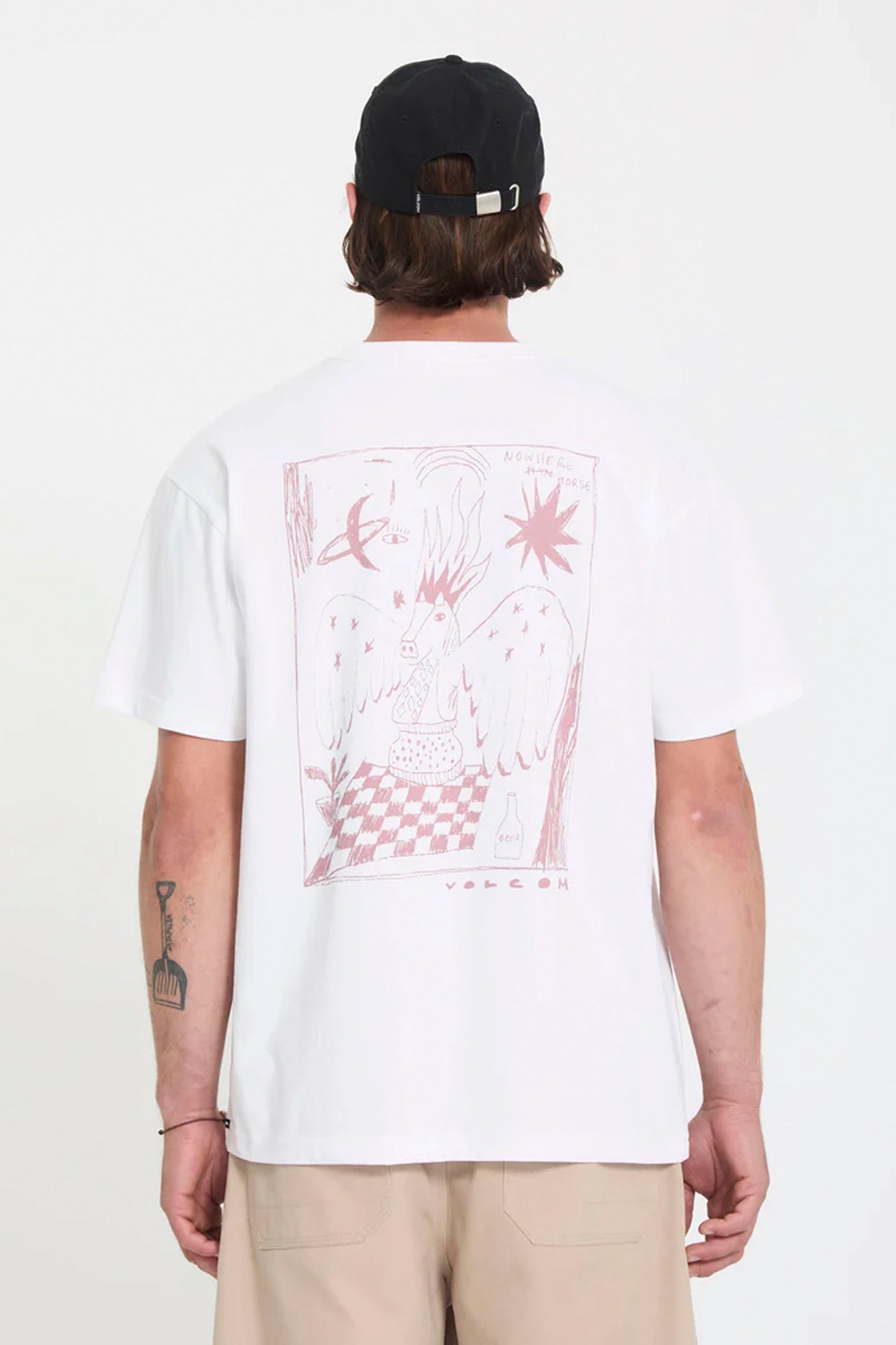 Person wearing a white Volcom Nowhere t-shirt with a graphic design on the back, standing against a plain background.