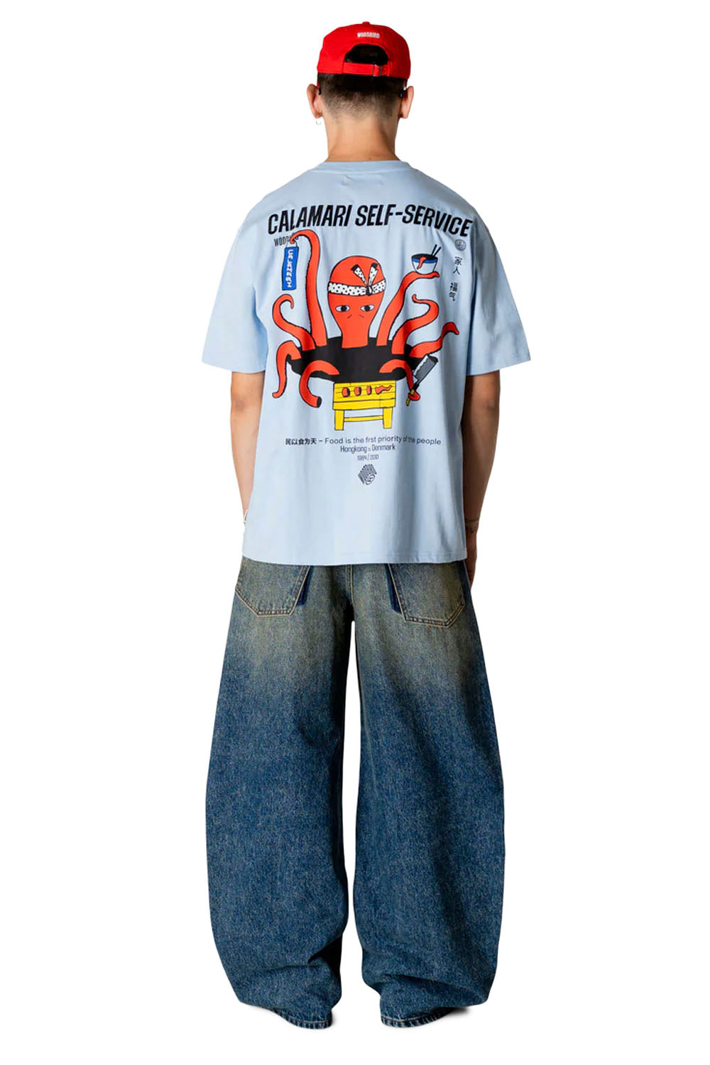 Person wearing a white t-shirt with a graphic design and blue jeans on a white background