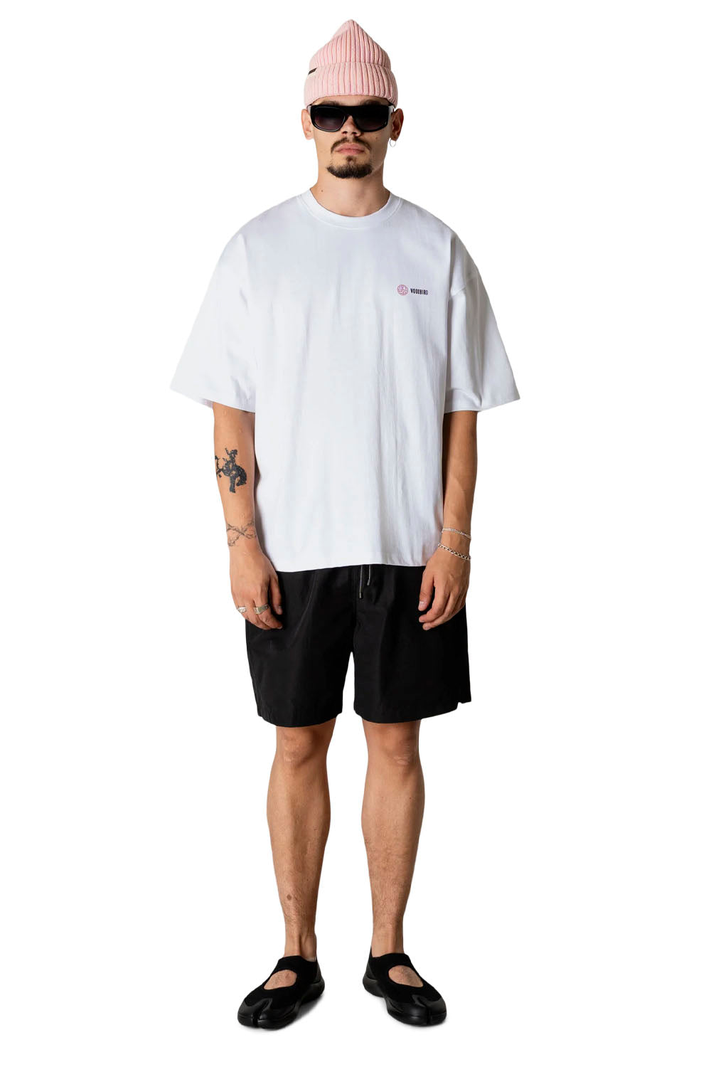 Person wearing a white t-shirt, black shorts, and a pink beanie on a white background