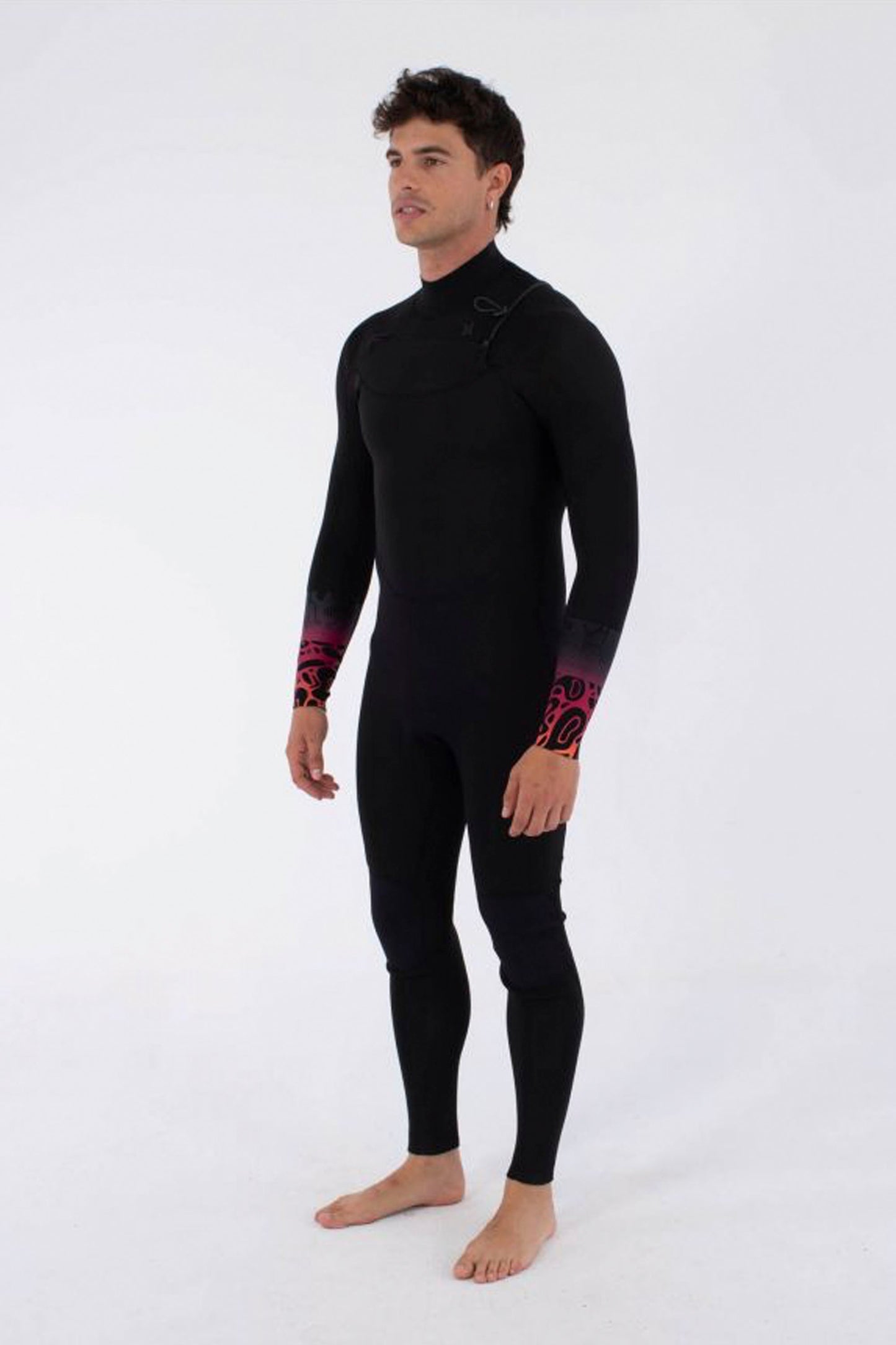 Man wearing a HURLEY Air 3/2mm Front Zip wetsuit with gradient bubble degrade print on a white background