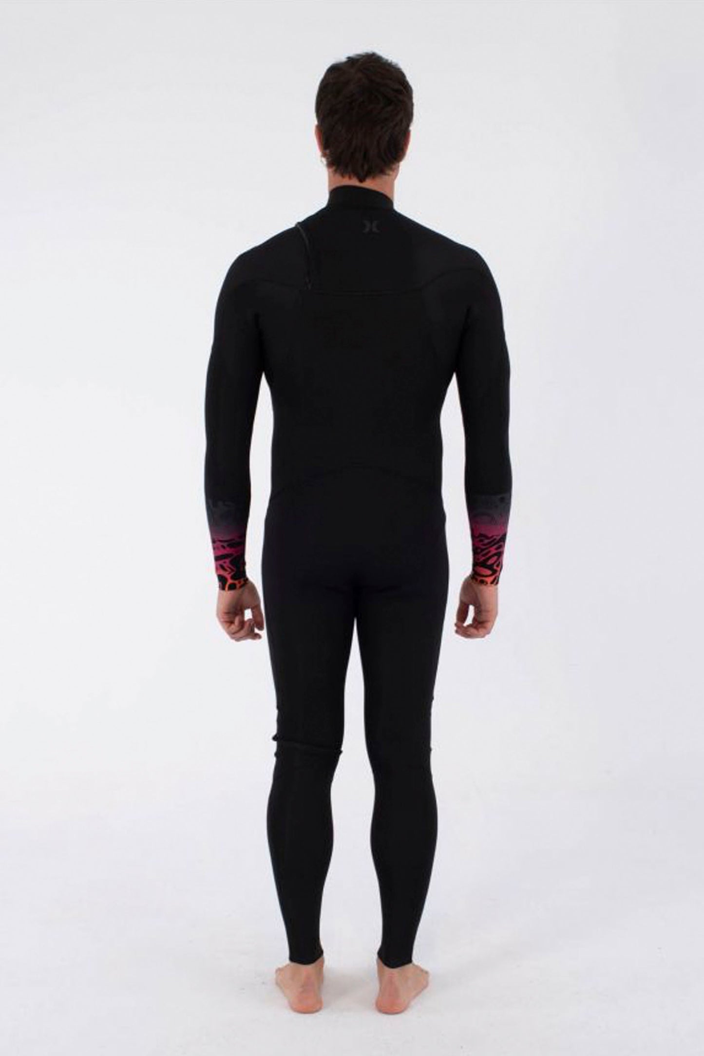 Man wearing a HURLEY Air 3/2mm Front Zip wetsuit with gradient bubble degrade print on a white background