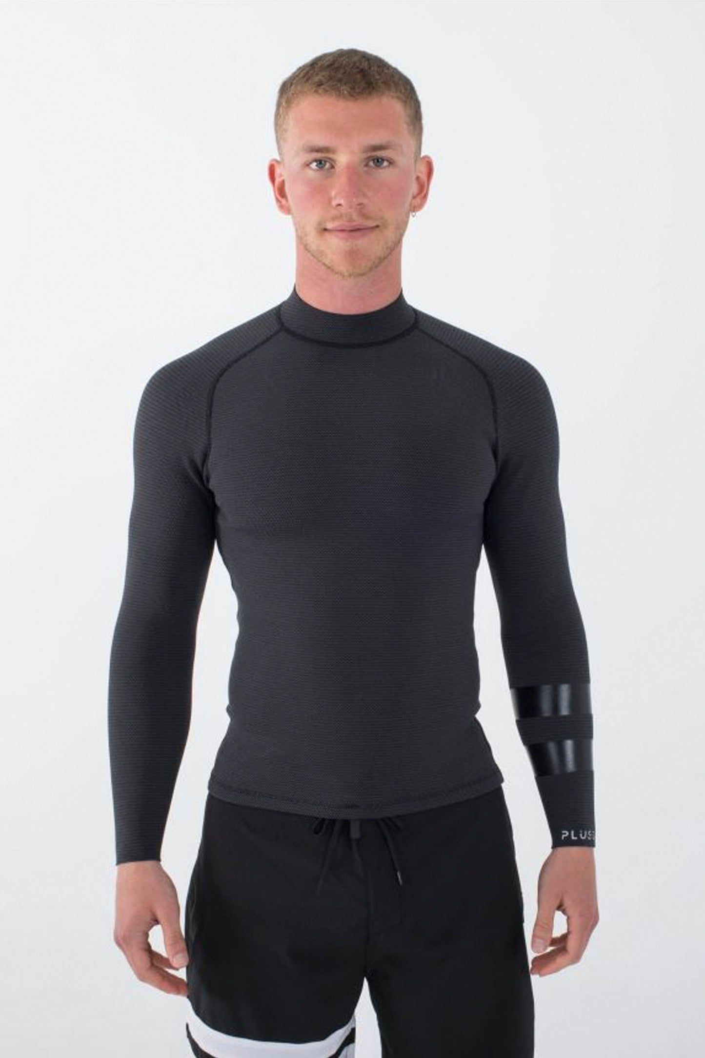 Man wearing a black long-sleeve Hurley Plus jacket on a white background