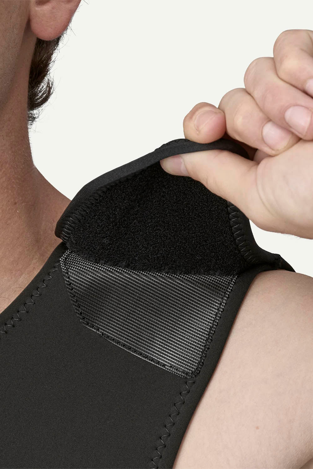 Person adjusting a black wrist support brace on their wrist.