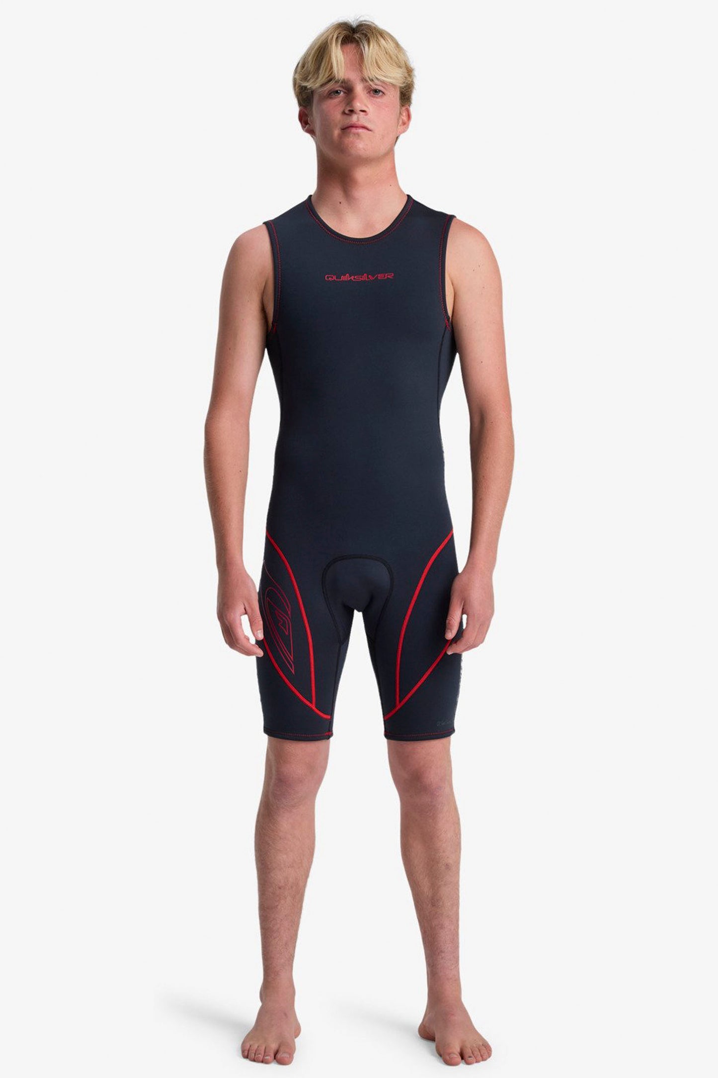 Person wearing a black and red Quiksilver short john wetsuit on a white background