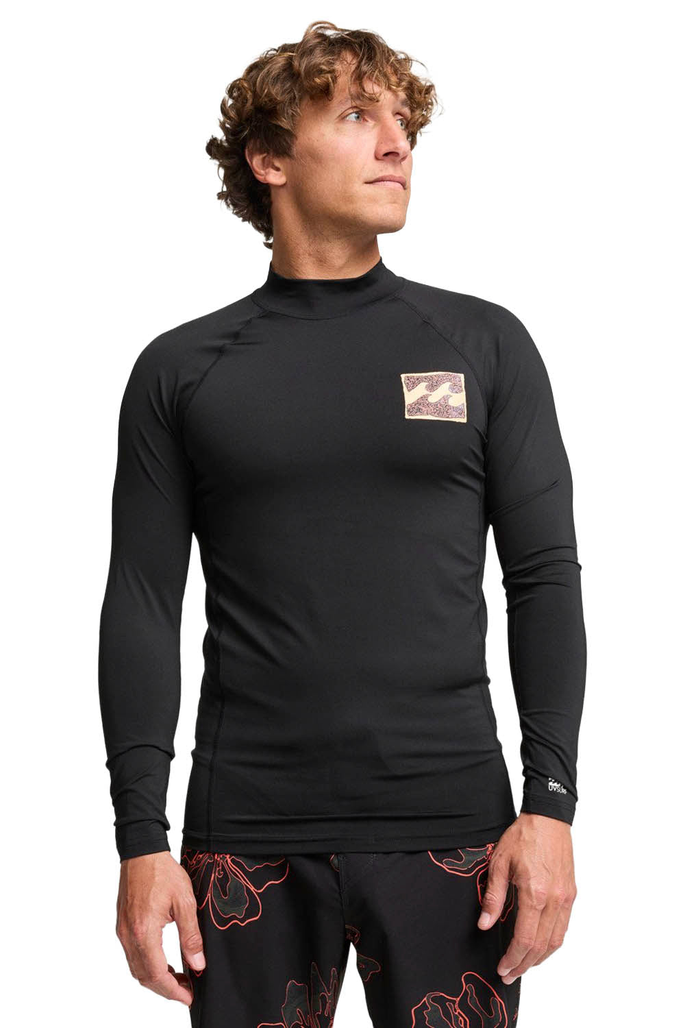 Man wearing black Billabong rashguard on a white background
