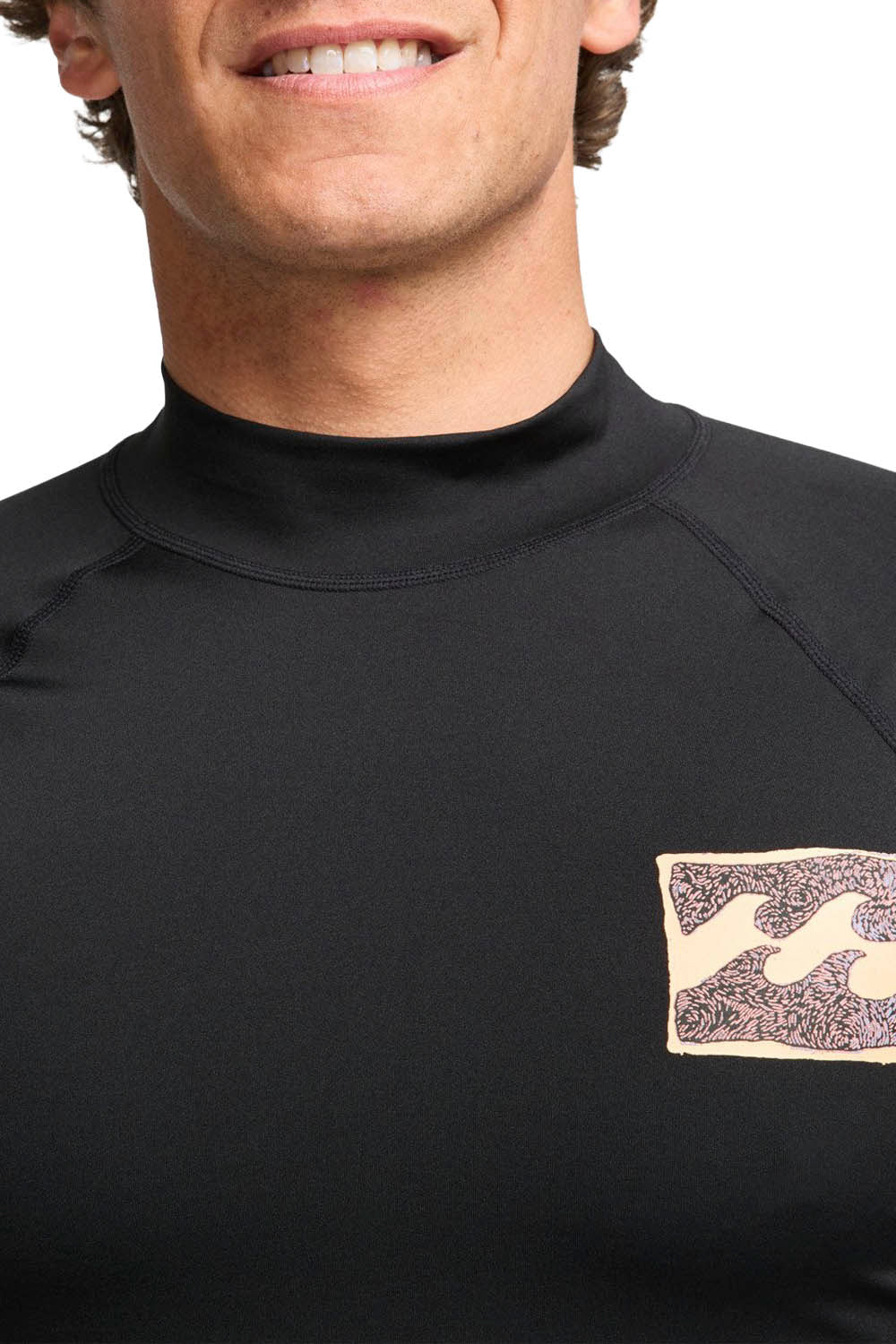 Man wearing black Billabong rashguard on a white background
