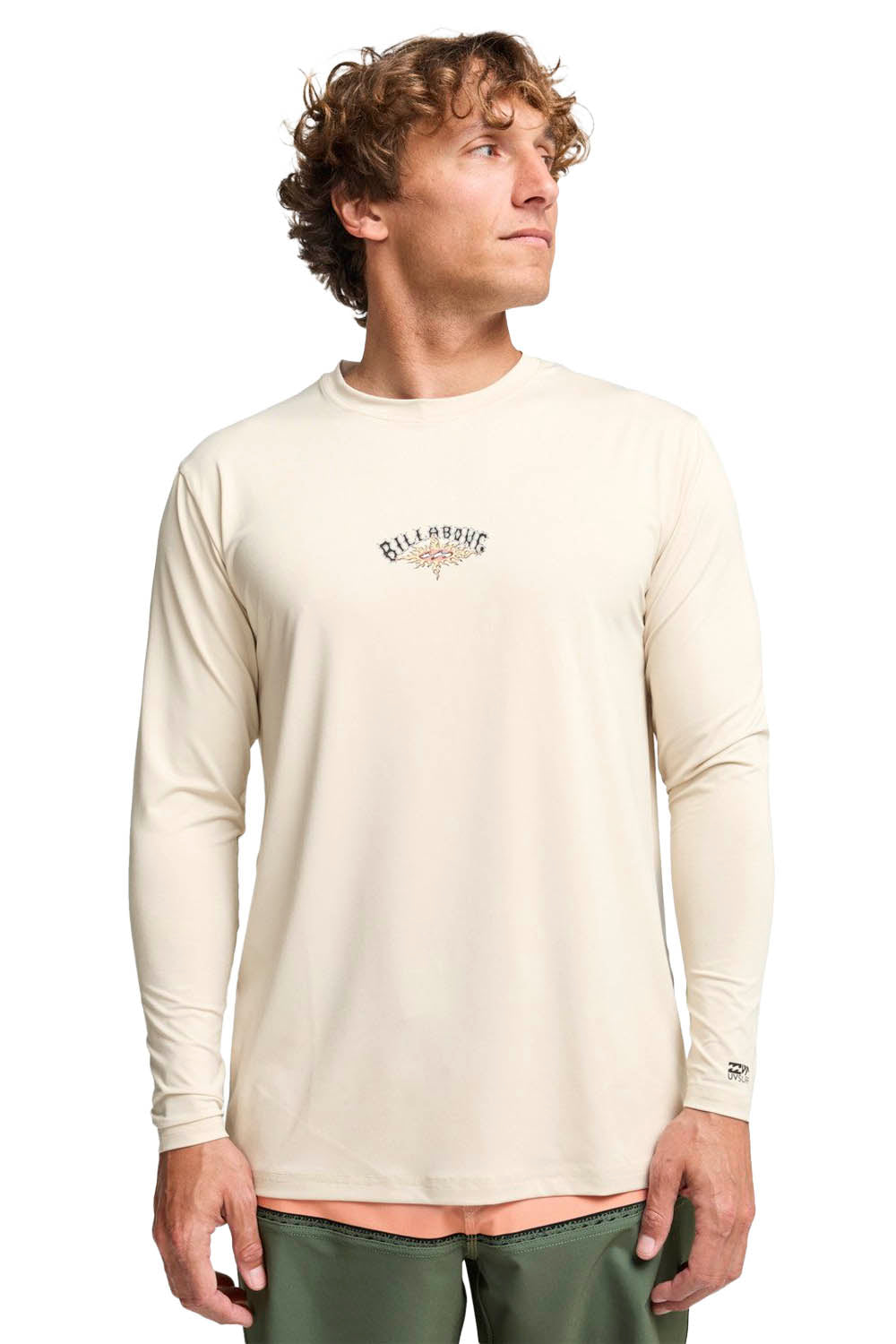 Man wearing a beige long-sleeve shirt with a logo on a white background