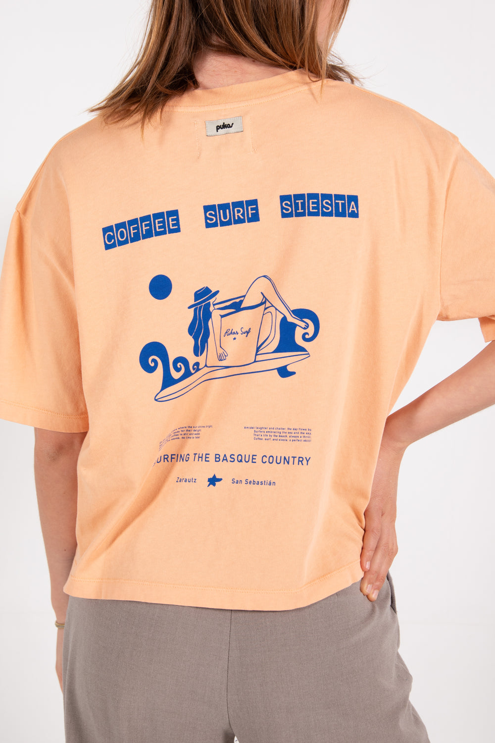 Pukas-Surf-Shop-Surfing-with-amigos-woman-coffee-surf-tee-orange