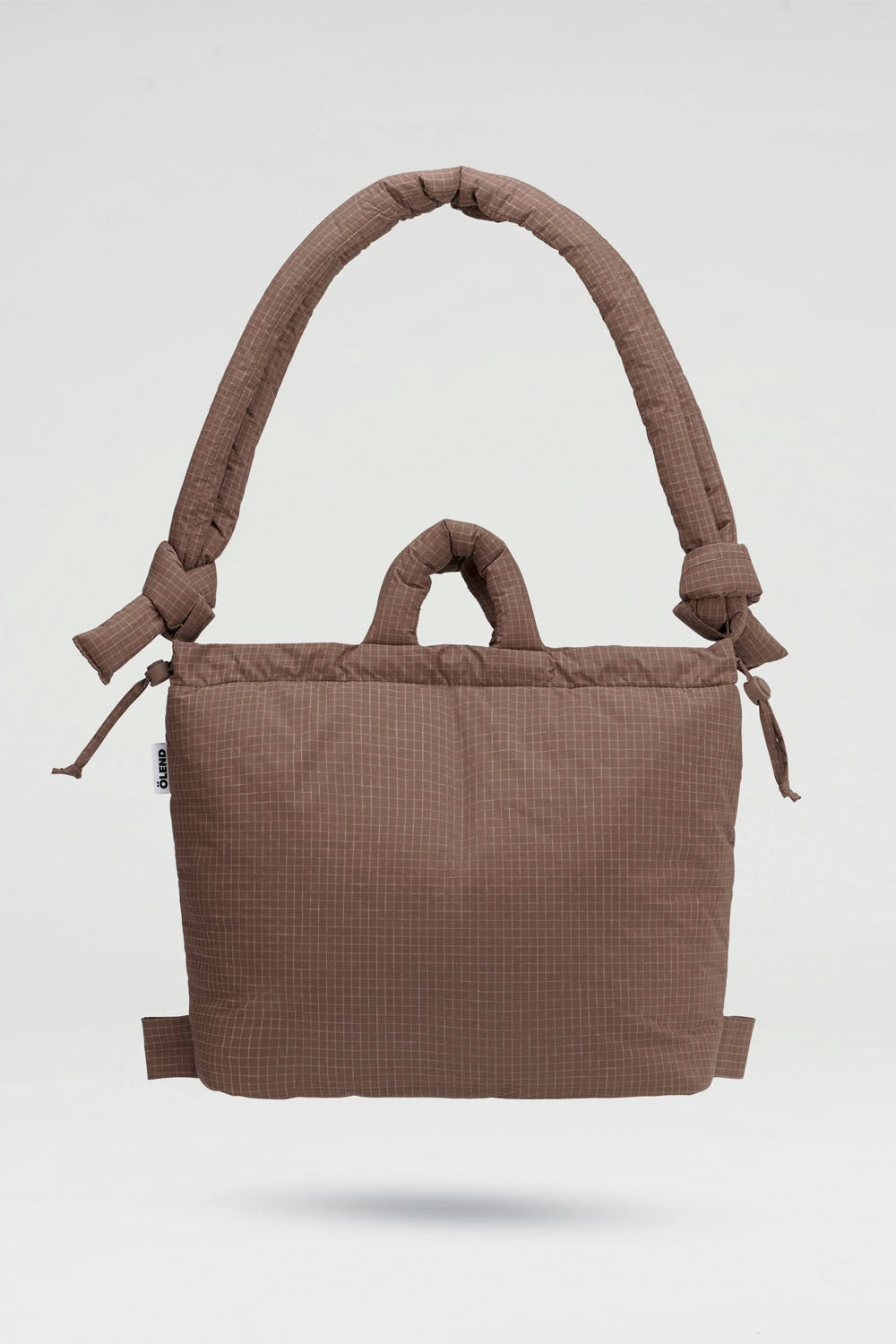 A brown textured fabric baby carrier bag with padded shoulder straps and top handles, shown floating against a light gray background.
