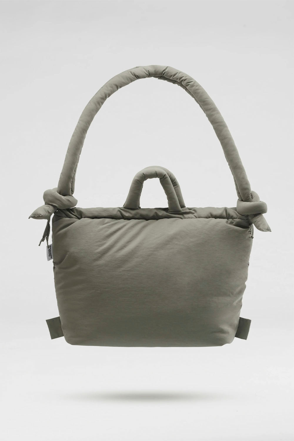 A light gray padded tote bag with thick, padded top handles and small side tabs, shown floating against a light gray background.