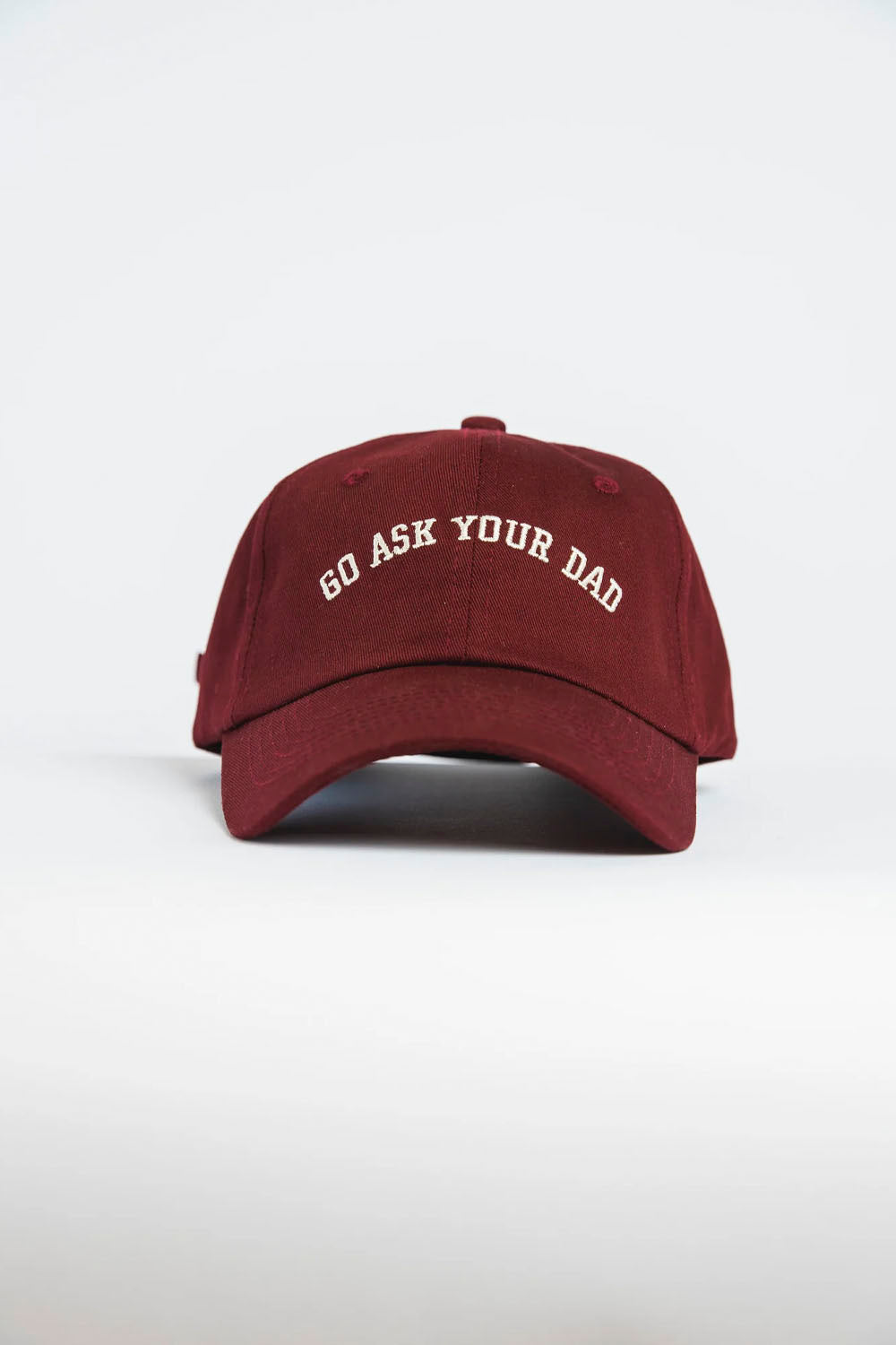 A burgundy baseball cap with 'GO ASK YOUR DAD' embroidered in white arched text on the front, set against a plain light gray background.