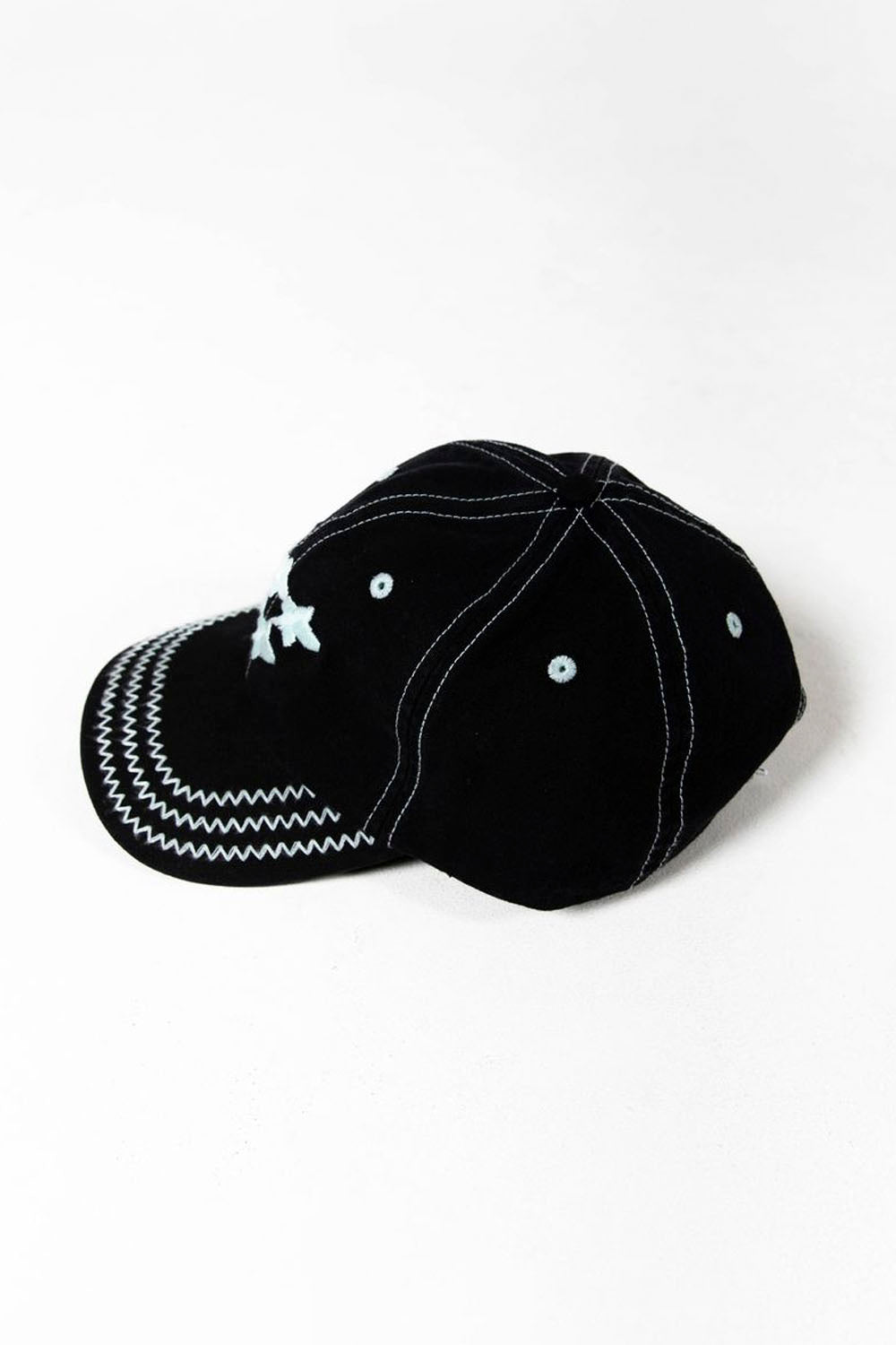 Black cap with white stitching on a white background