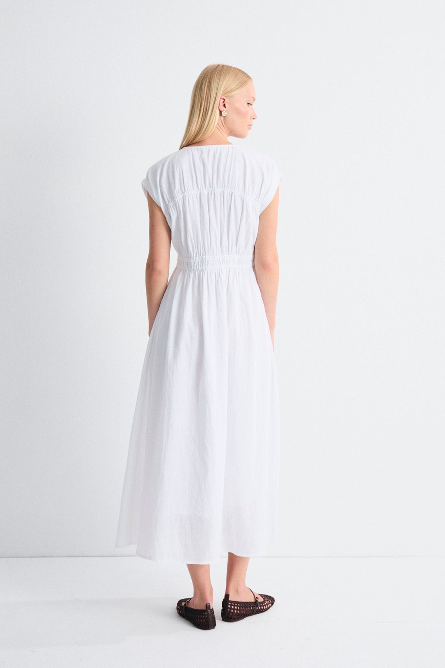 Woman wearing a white dress on a plain background