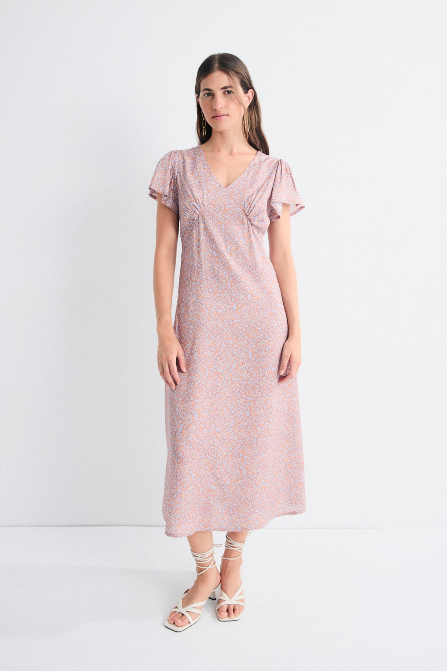 Woman wearing a pink dress with a white background