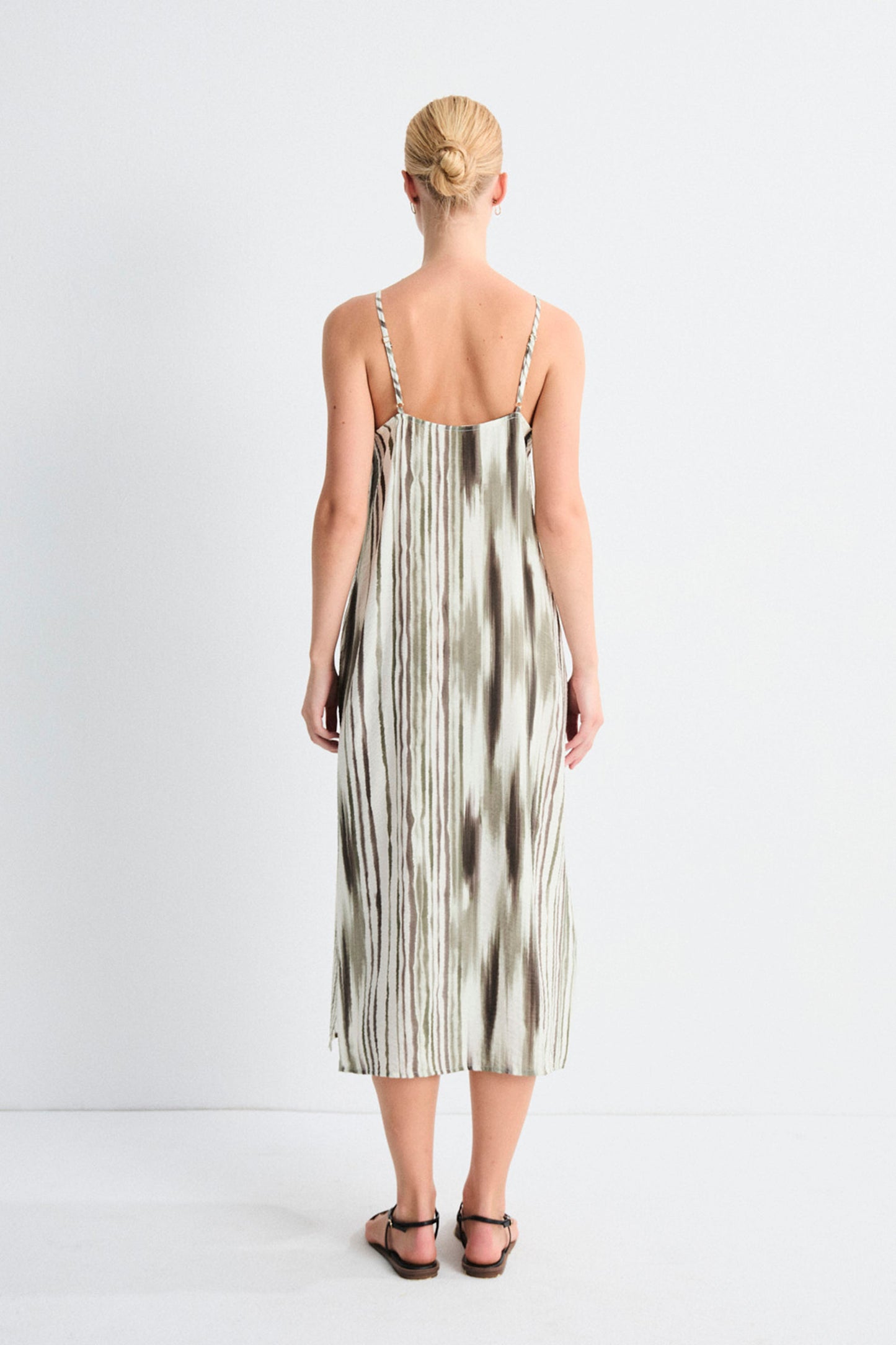 Woman wearing a tie-dye dress on a white background