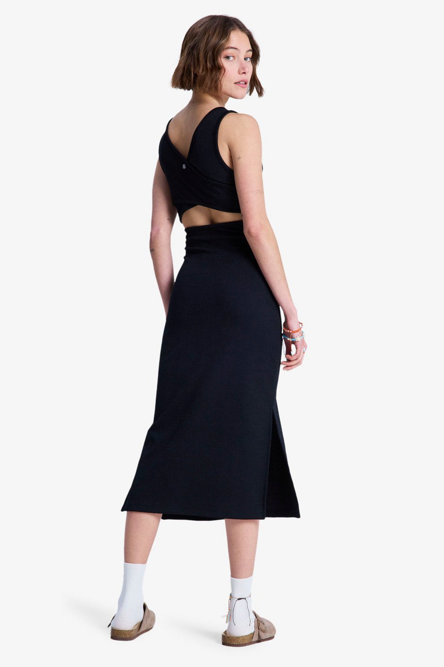 Woman wearing a black  ROXY Good Keepsake  dress with cut-out design on a white background