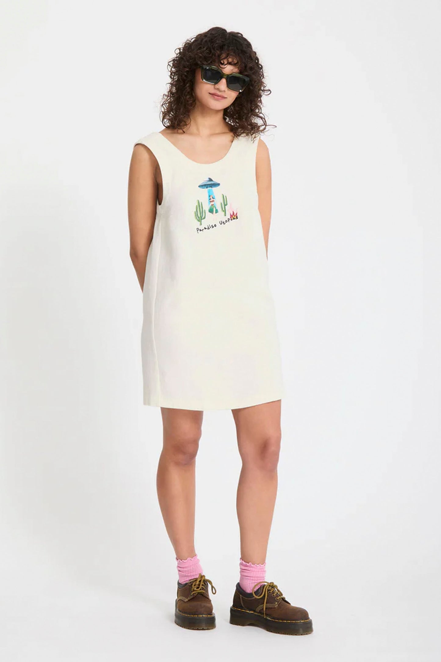 Person wearing a white Volcom Fa Mickey Mason dress with a graphic design on a plain background