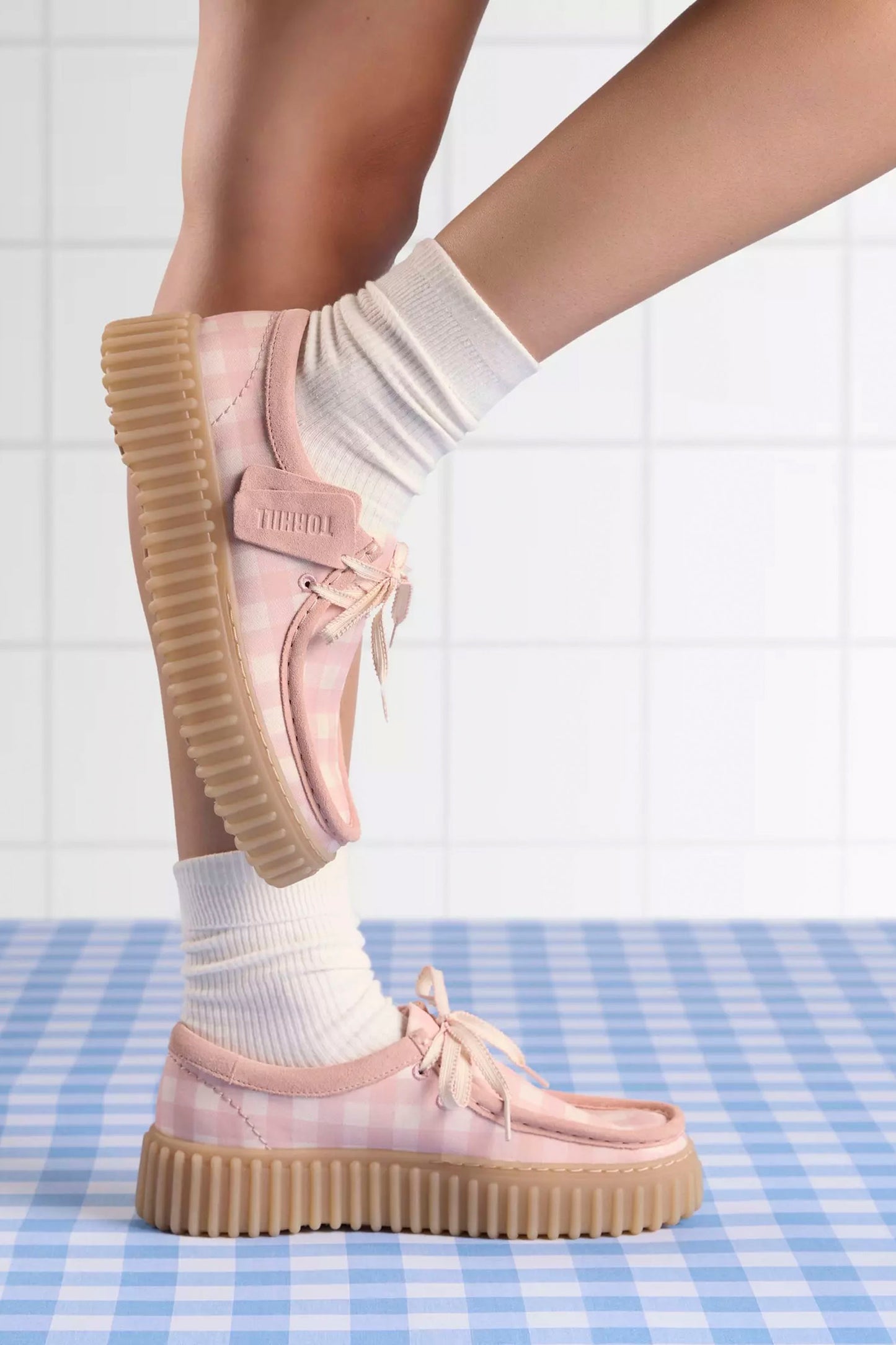 Light pink Clarks Tornhill Bee shoe with beige soles worn on a checkered floor.