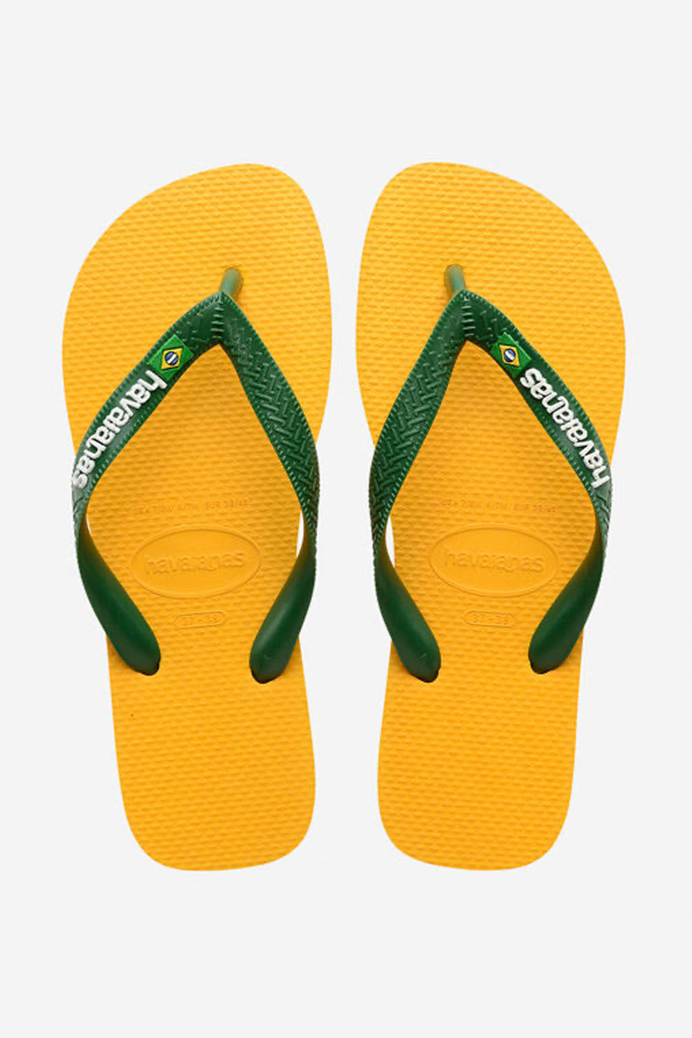Yellow flip-flops with green straps on a white background