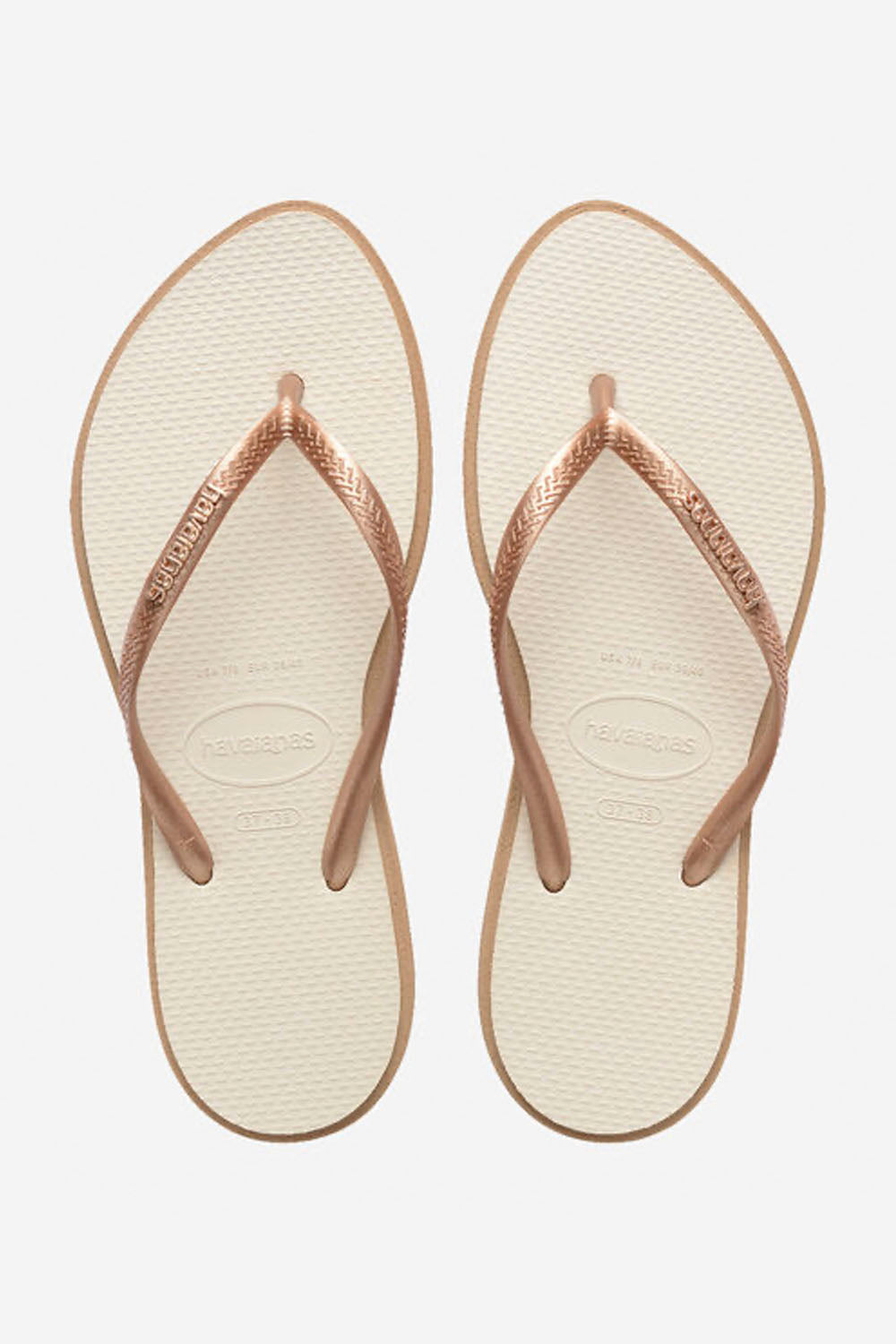 Pair of beige flip-flops with rose gold straps on a white background