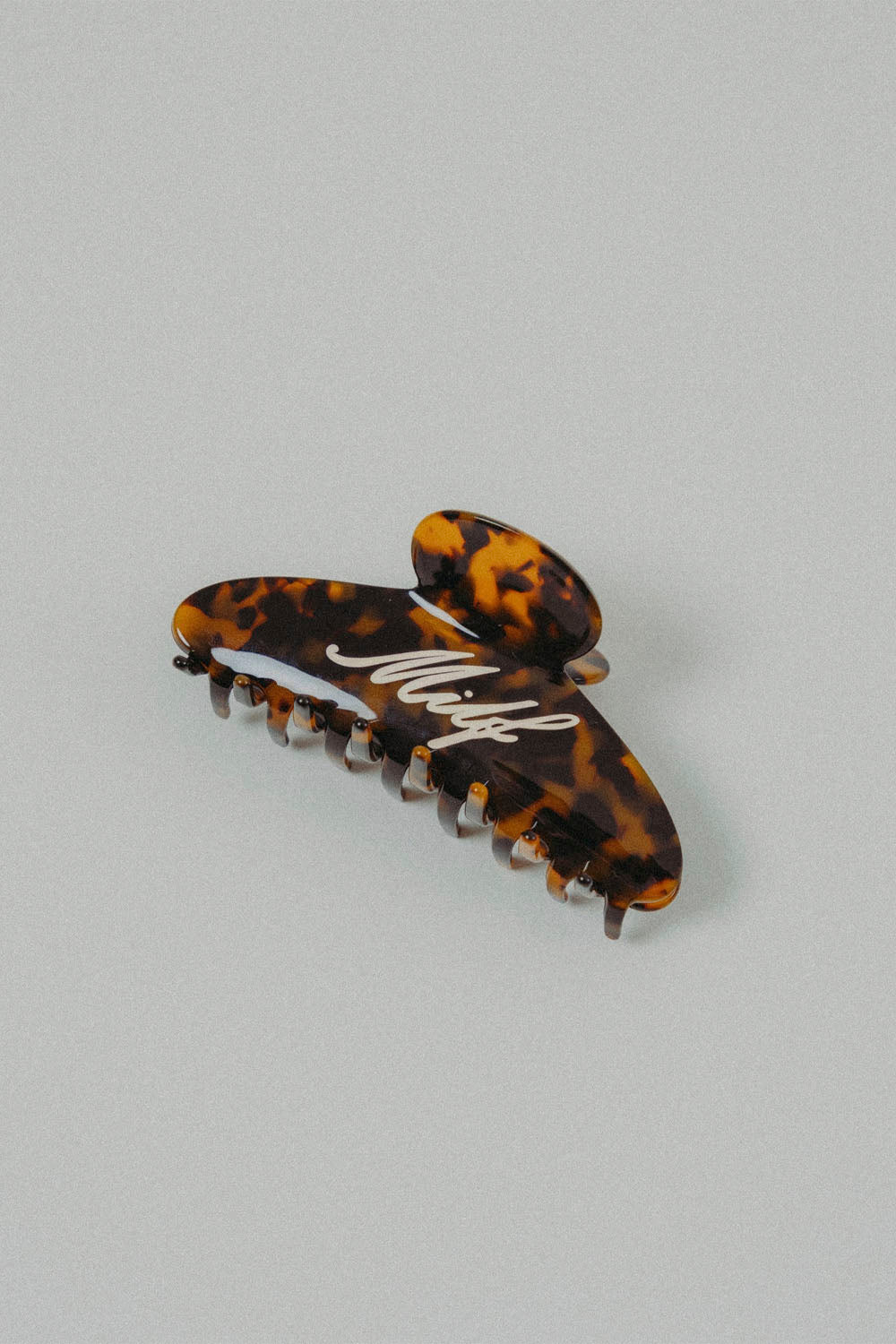 Brown hair clip with a bold, tongue-in-cheek attitude, made to keep your hair up on sunny beach days. Available Online at Pukas Surf Shop.