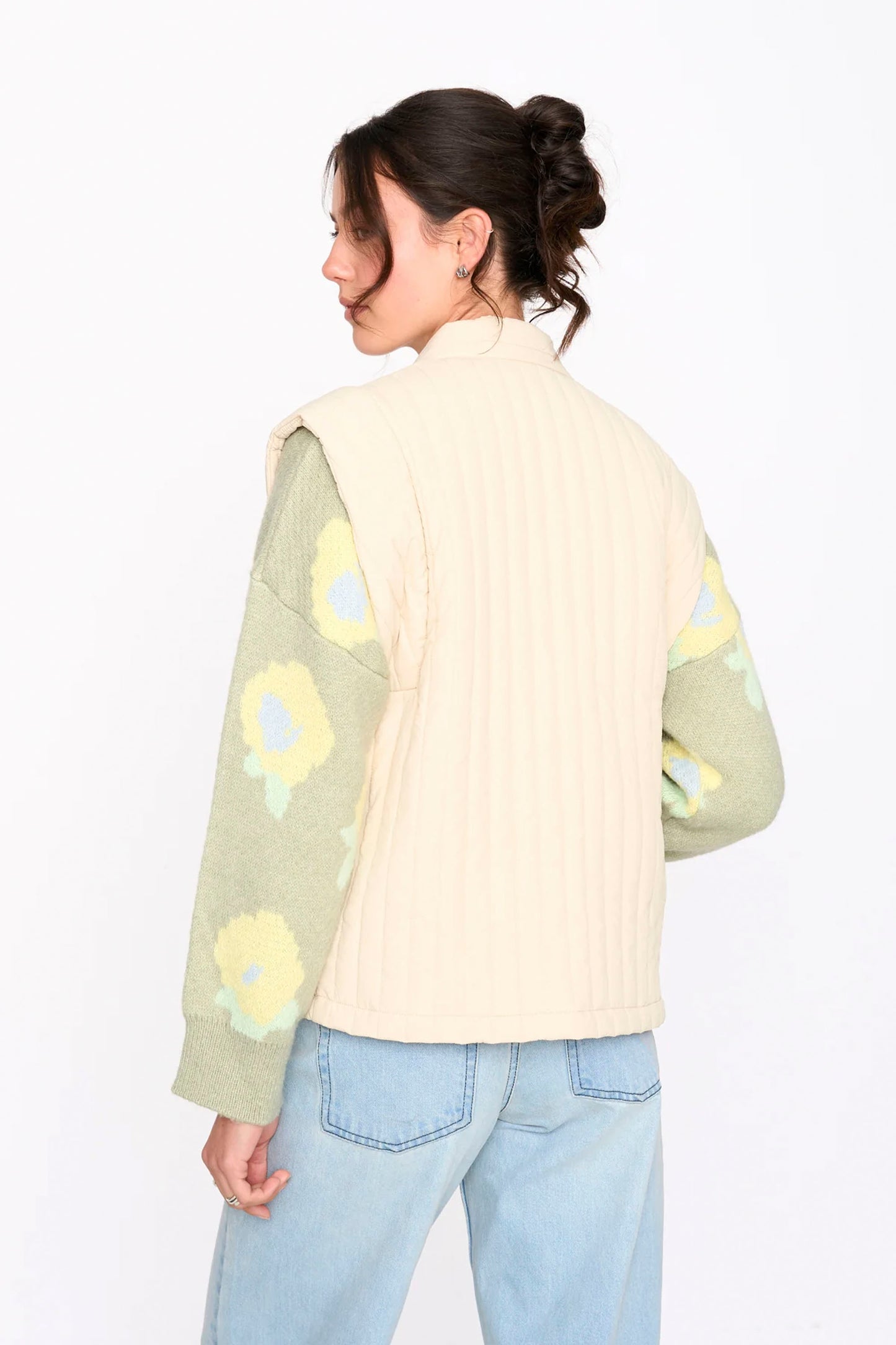 Woman wearing a beige 24colours quilted vest on a white background