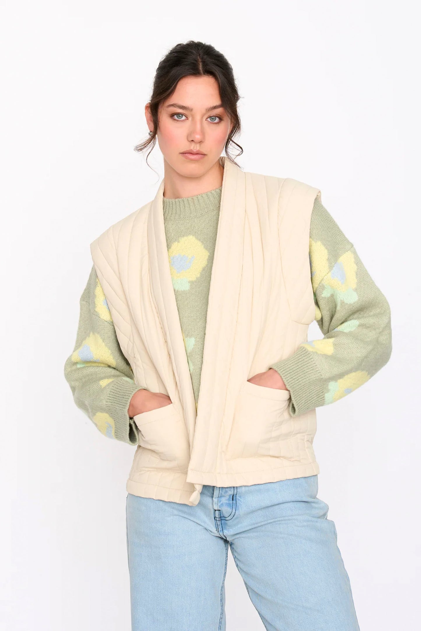 Woman wearing a beige 24colours quilted vest on a white background