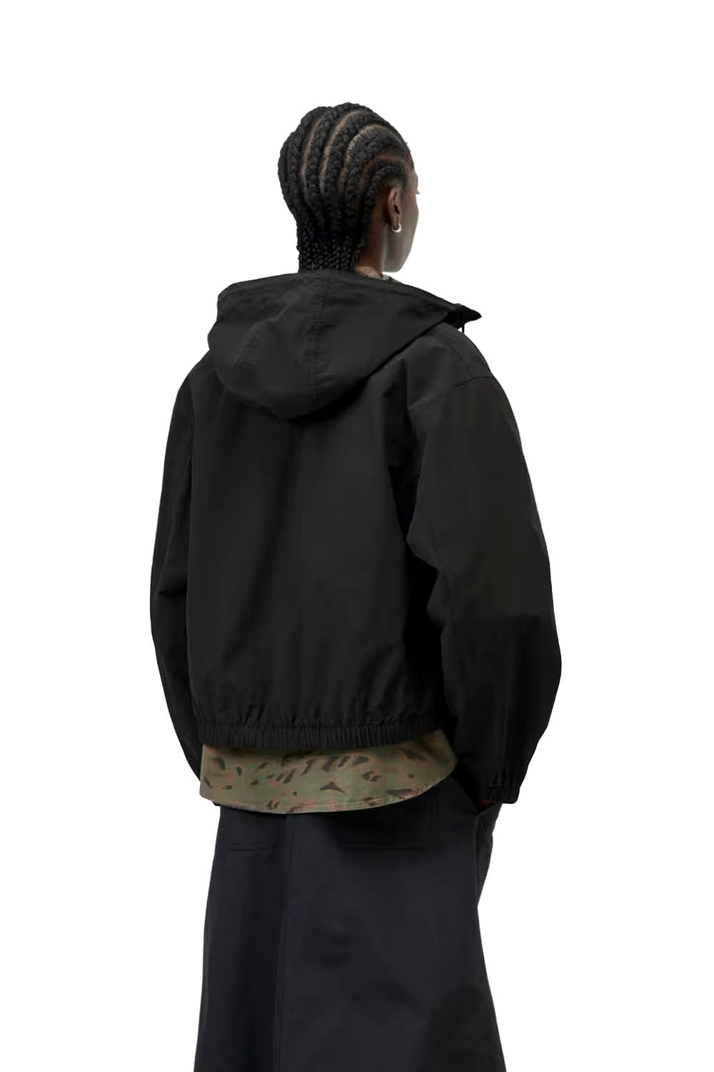 Person wearing a black jacket with a hood on a white background