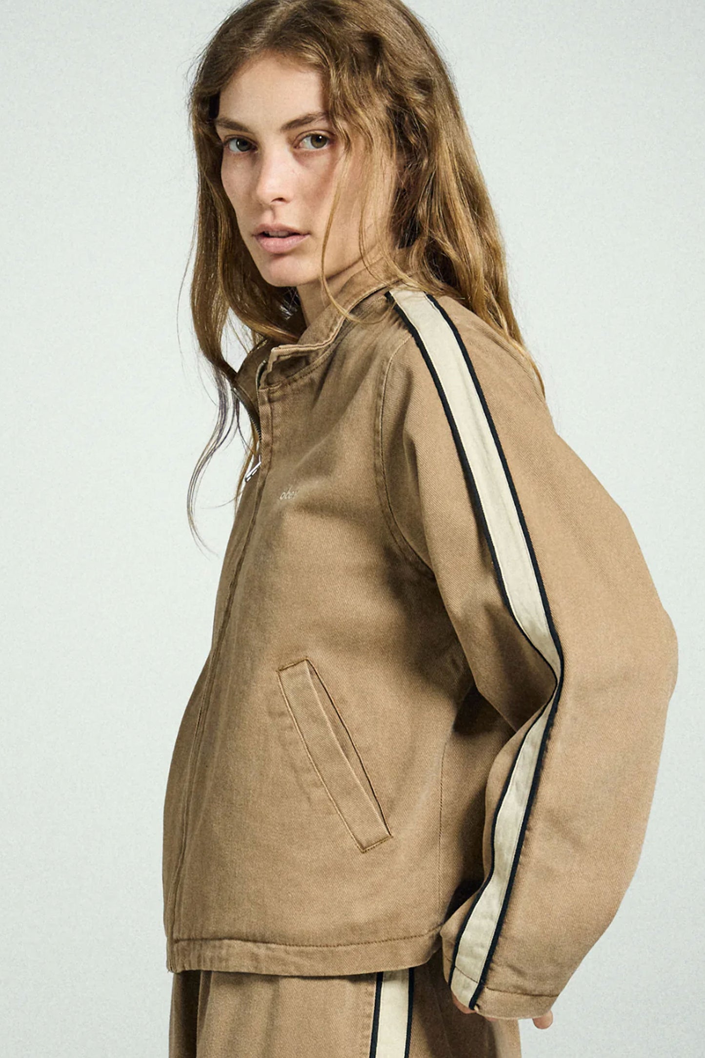 Woman wearing a Obey beige jacket with white trim Pukas Surf Shop