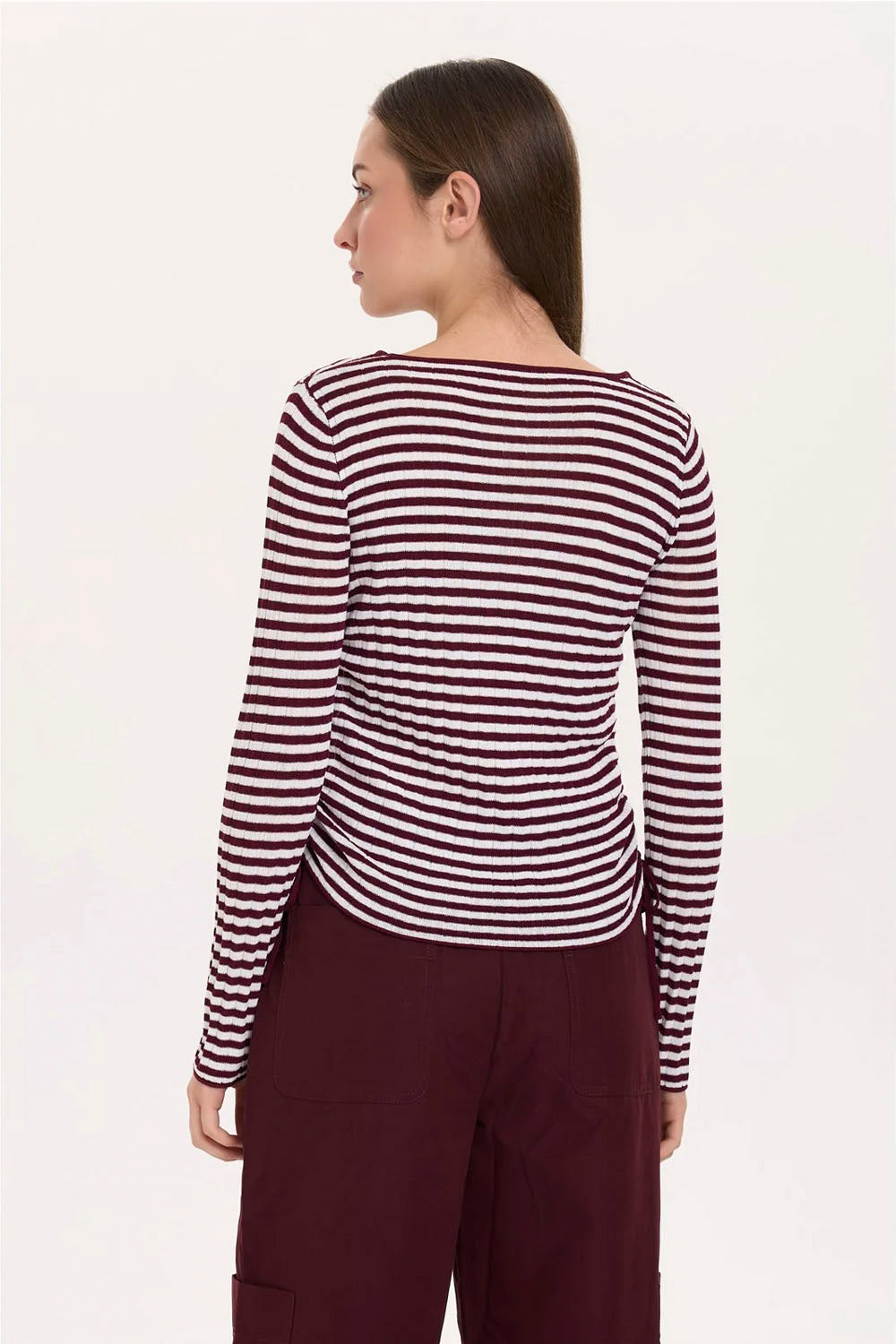 A woman shown from the back wearing a long-sleeve top with horizontal burgundy and white stripes, paired with dark burgundy pants, against a plain white background.