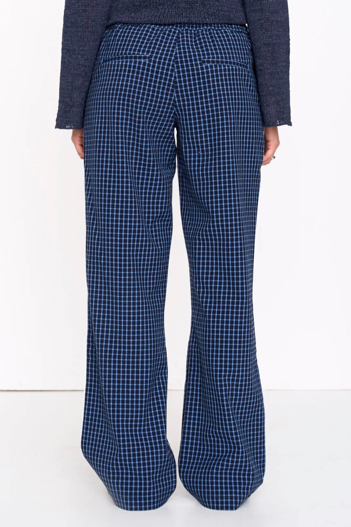 Woman wearing blue 24colours checked pants on a white background