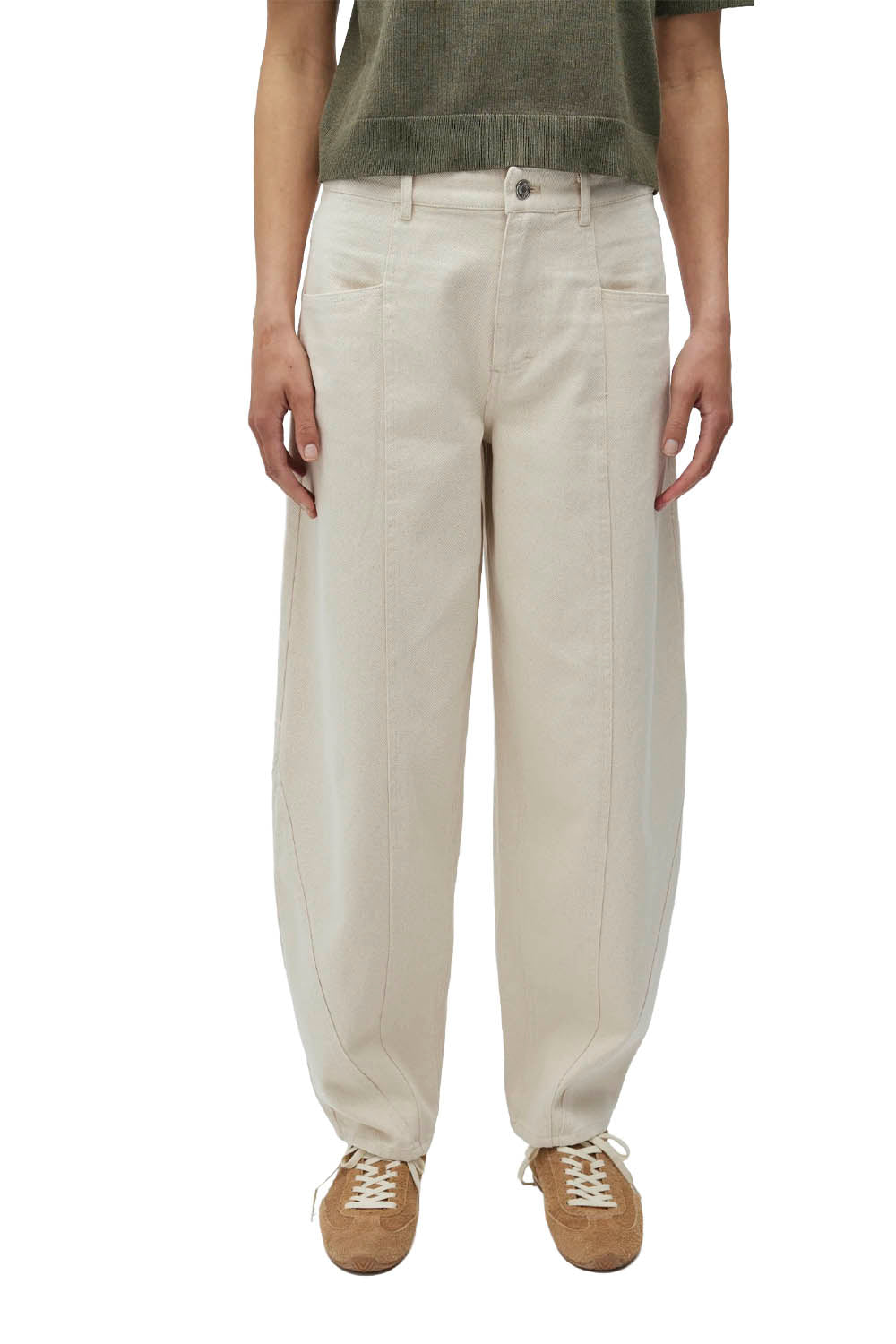 Person wearing beige pants and a green top on a white background