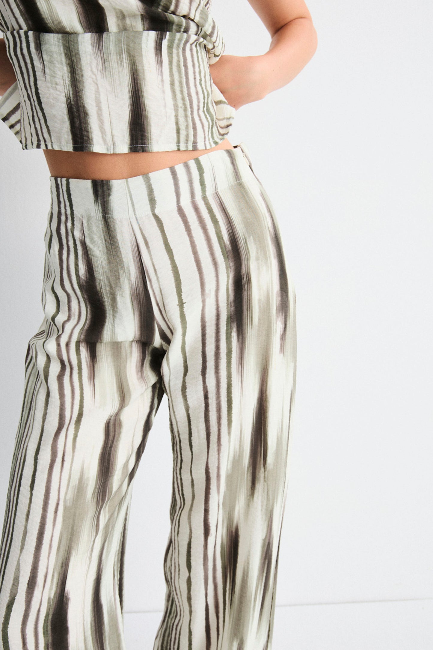 Person wearing a green and white striped outfit on a light gray background