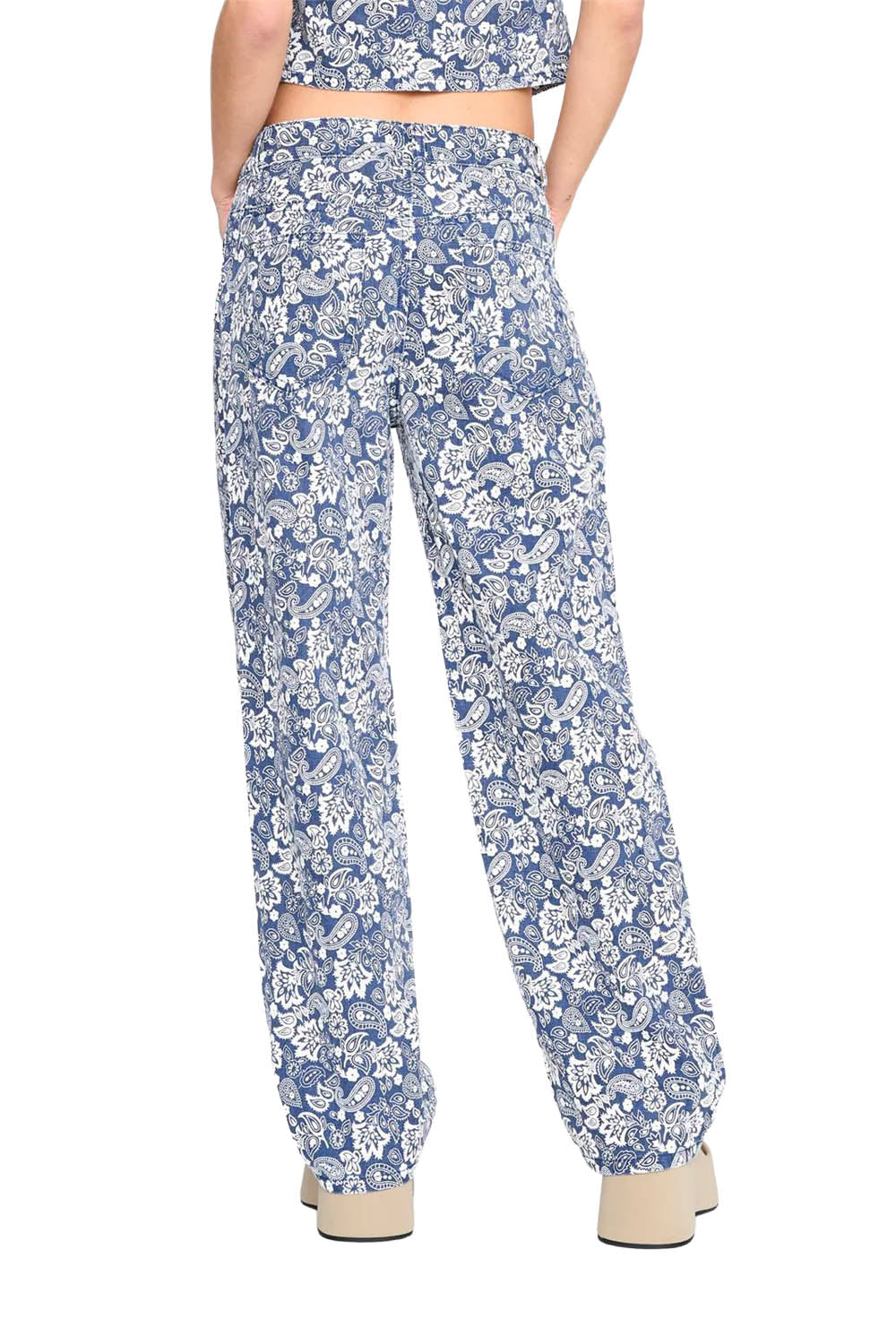 Person wearing blue floral pants on a white background
